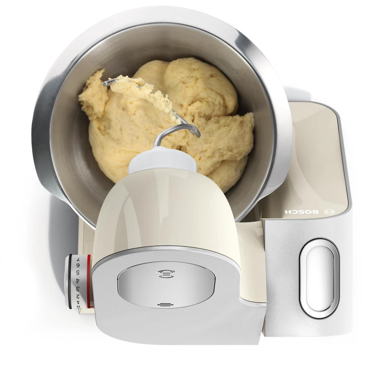 Beige Küchenmaschine mit Teig in der Schüssel, Draufsicht, weißer Hintergrund.