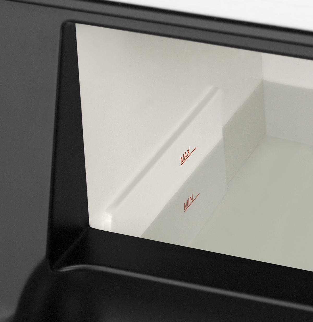 Zbliżenie wnętrza czarnego pojemnika. Posiada wskaźniki poziomu Max i Min w kolorze białym.