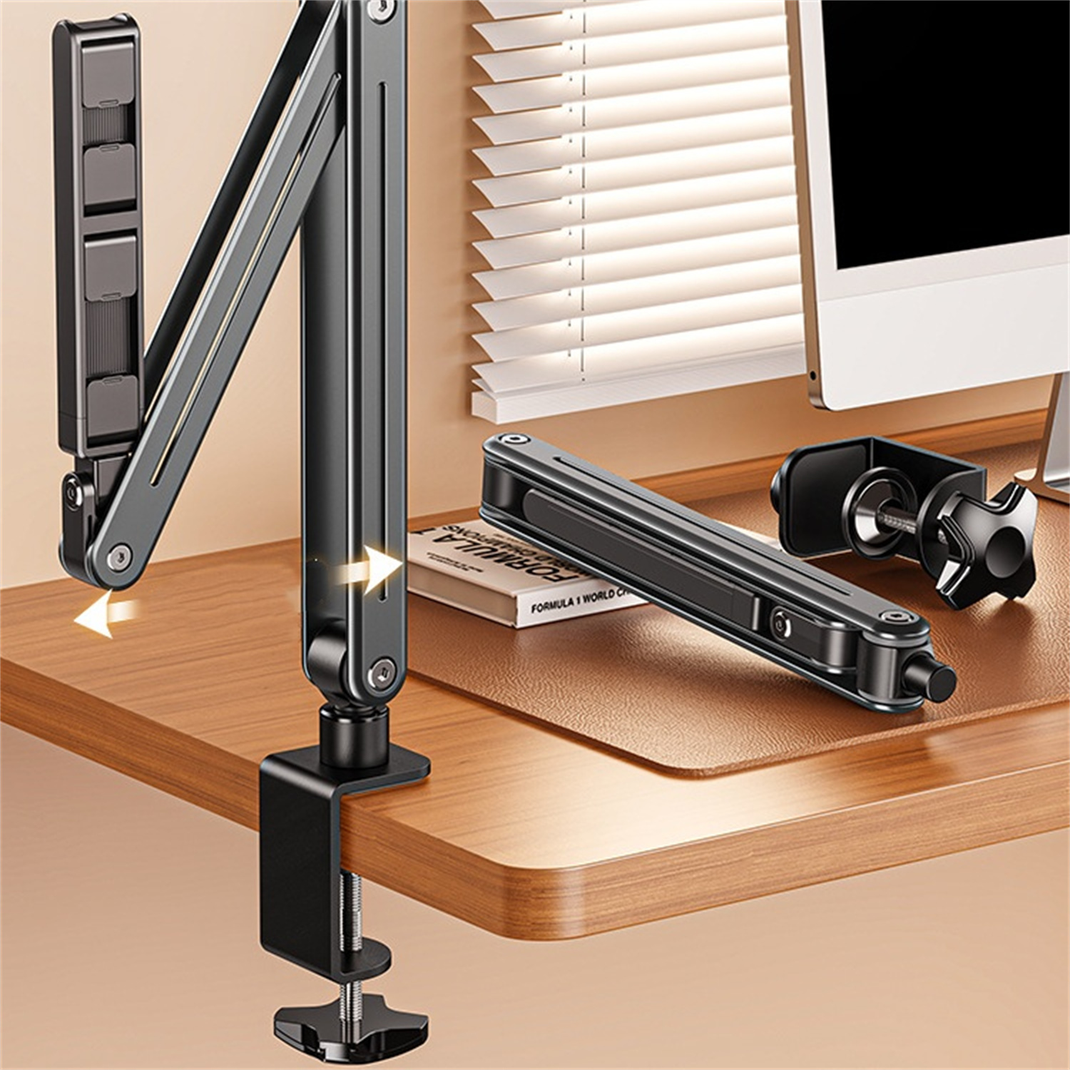 Monitorarm-Setup. Schwarzer Arm mit Klemme auf einem Holzschreibtisch.