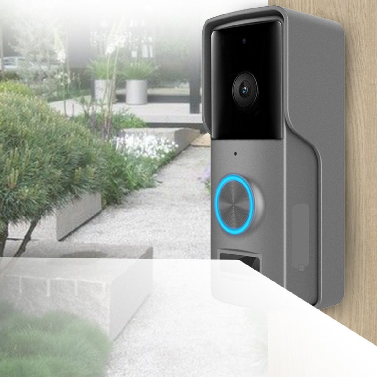 Graue intelligente Türklingel mit Kamera, Knopf mit blauem Licht und kleinem, grünen Garten im Hintergrund.