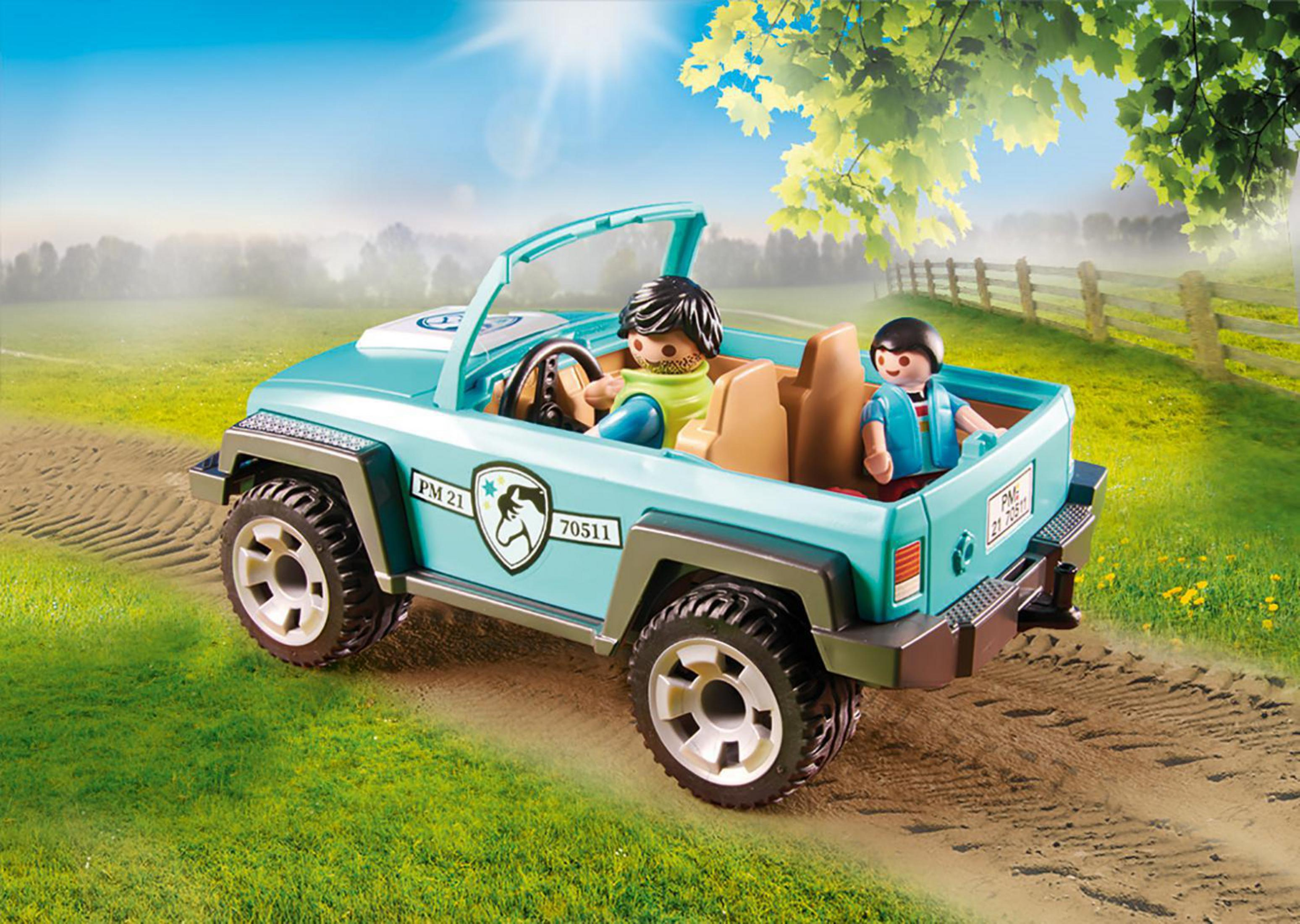 Voiture jouet avec deux figurines. Voiture bleue sur un champ vert. Sièges marrons. Arbres verts et ciel bleu.