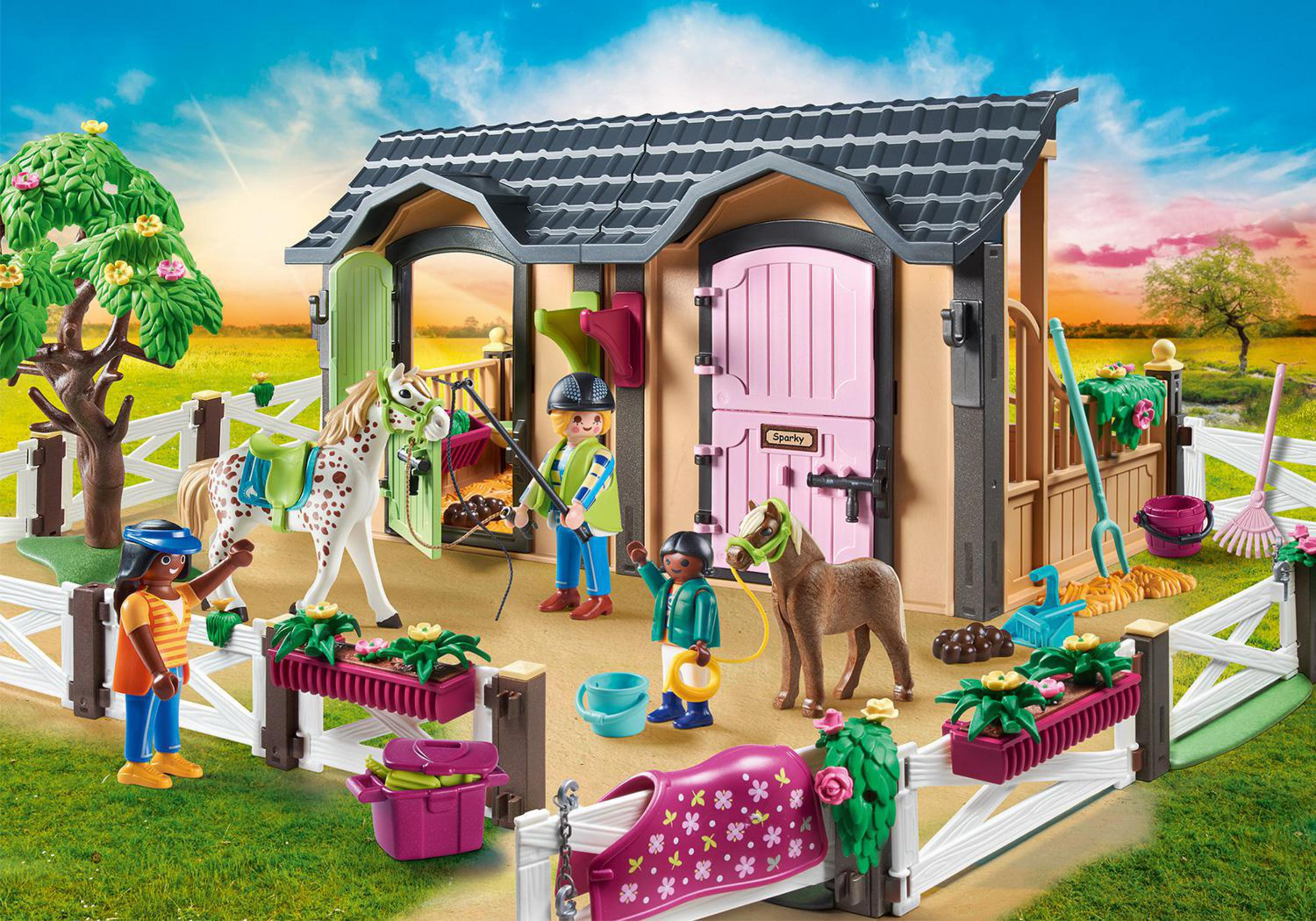 Une scène d'écurie Playmobil avec des figurines de personnes et de chevaux.