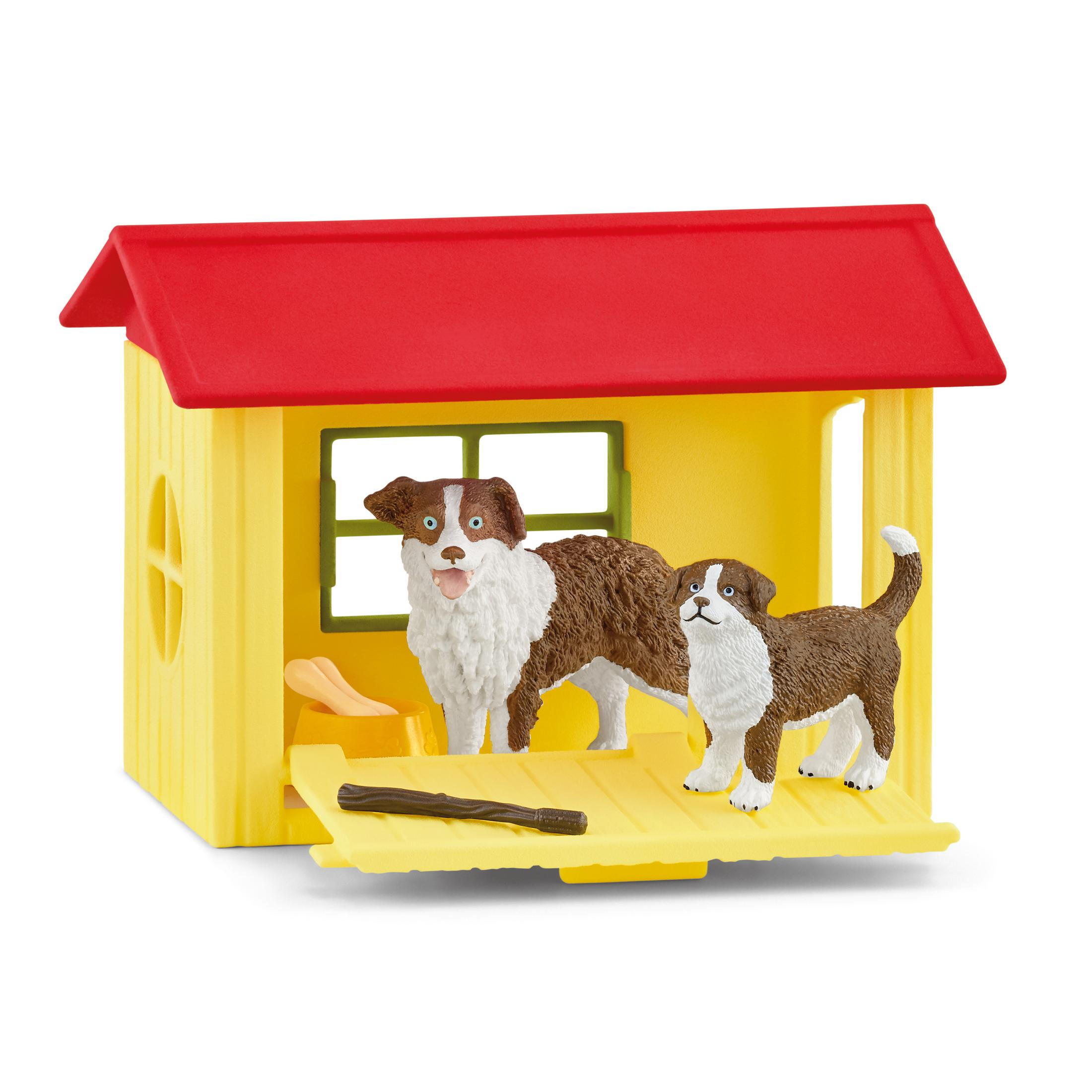 Spielzeug-Hundehütte mit zwei Spielzeug-Hunden. Einer ist braun und weiß, der andere ist braun und weiß.