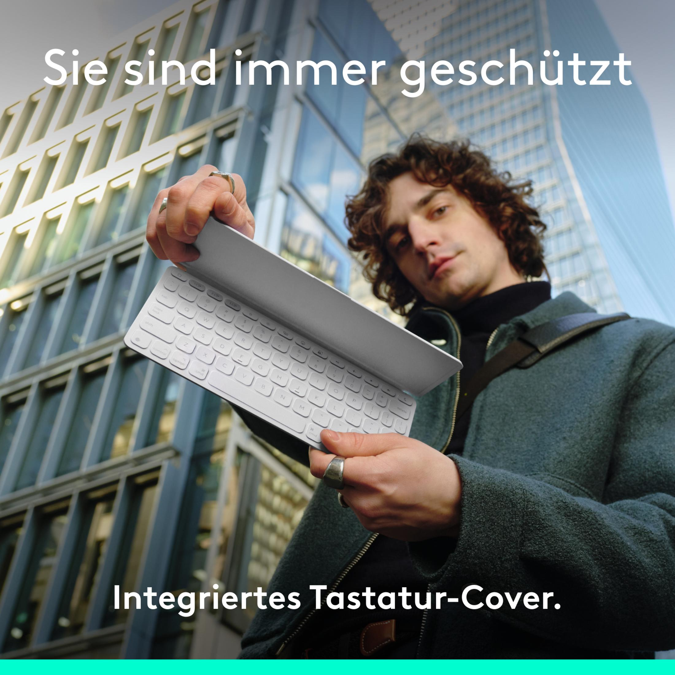 Mann hält weiße Tastaturabdeckung vor Glasgebäude. Text: Integrierte Tastaturabdeckung.
