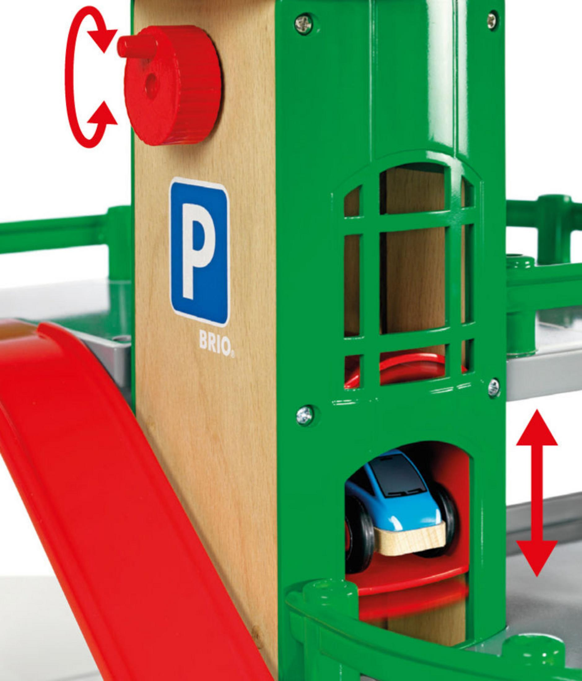 Un garage di parcheggio giocattolo in legno. Una rampa rossa. Un'auto blu è all'interno.