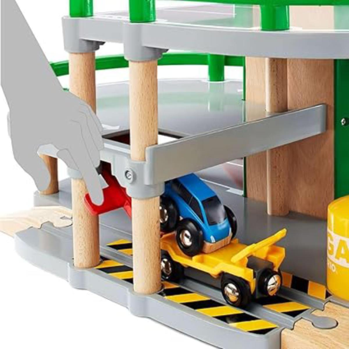 Una mano aziona una leva rossa su un garage giocattolo in legno con un'auto blu su un carrello giallo.