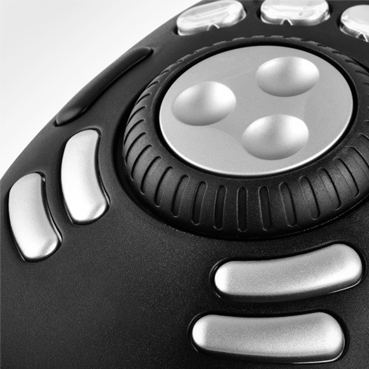 Nahaufnahme eines schwarzen Gamecontrollers mit silbernen Knöpfen. Die Knöpfe sind kreisförmig angeordnet.