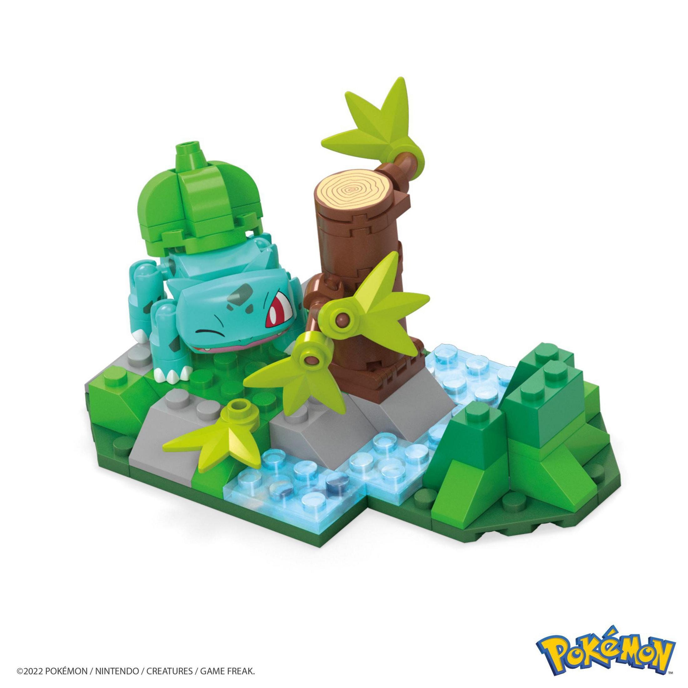 Bulbasaur-Figur in einem Bausatz mit Baum und Wasser. Grüne, braune und blaue Farben.