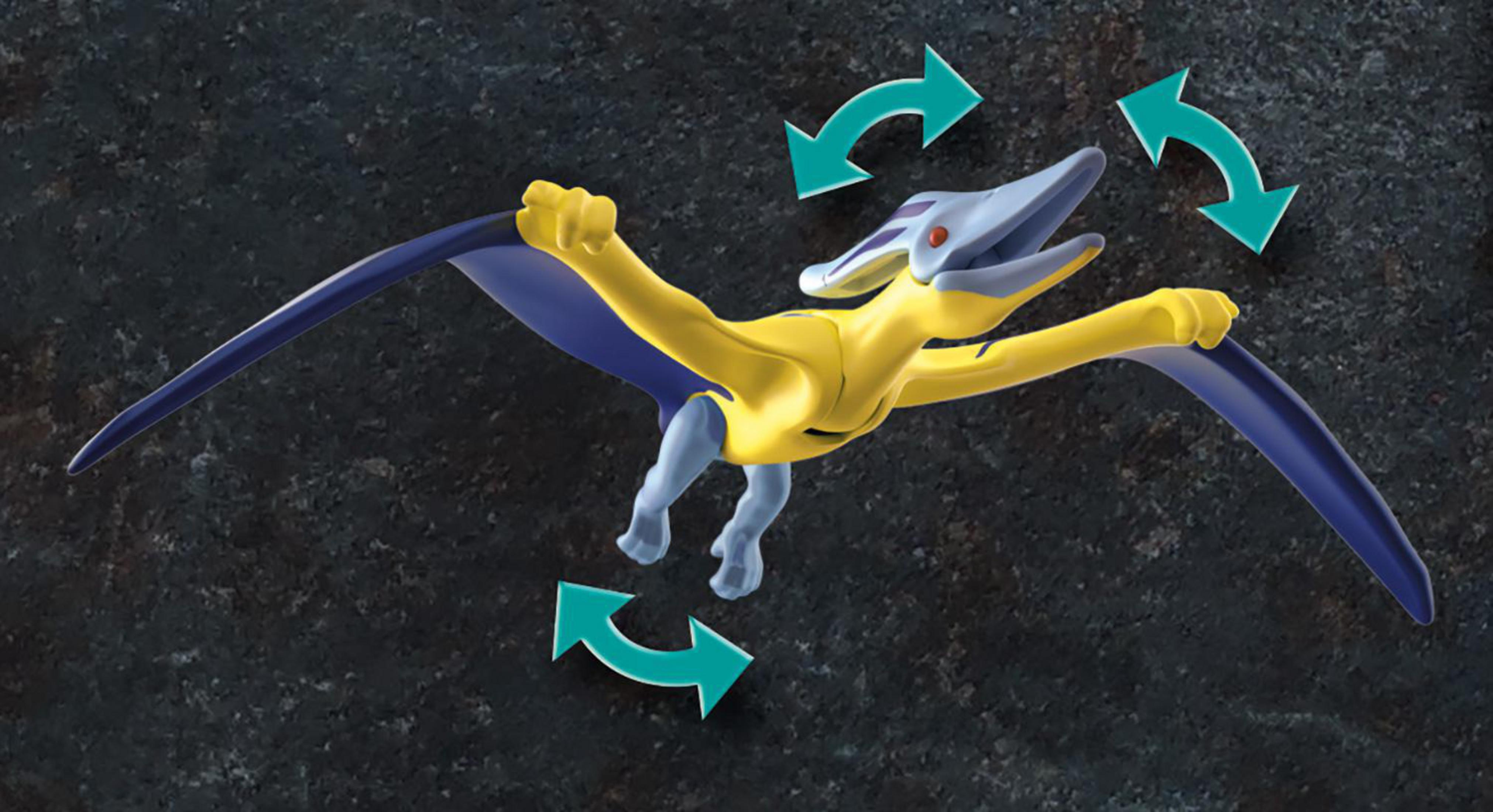 Gelb-blaues Spielzeug-Pterodaktylus mit Pfeilen, die Bewegung auf dunklem Hintergrund anzeigen.