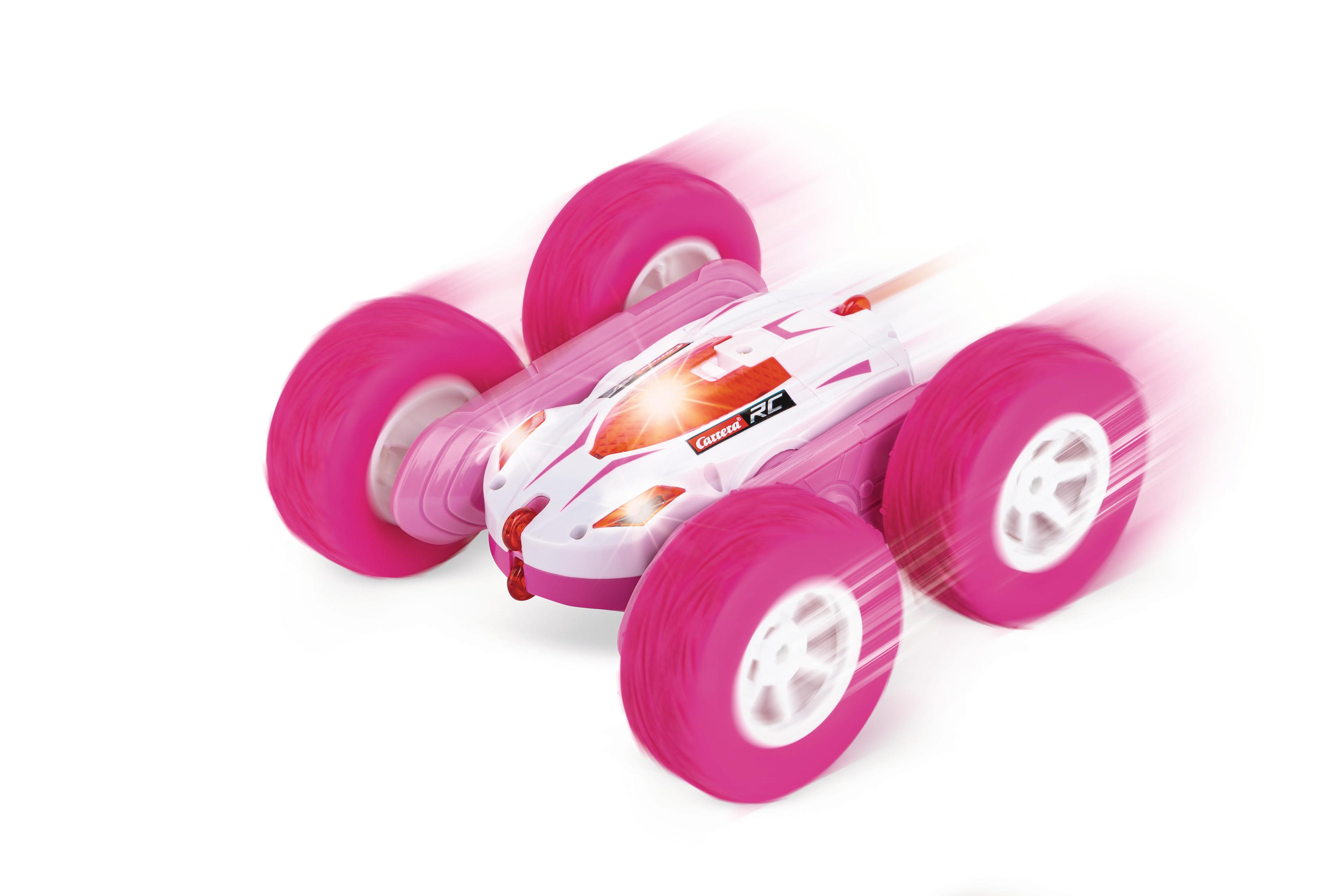Un'auto giocattolo rosa e bianca in movimento, con quattro grandi ruote rosa e una carrozzeria bianca.