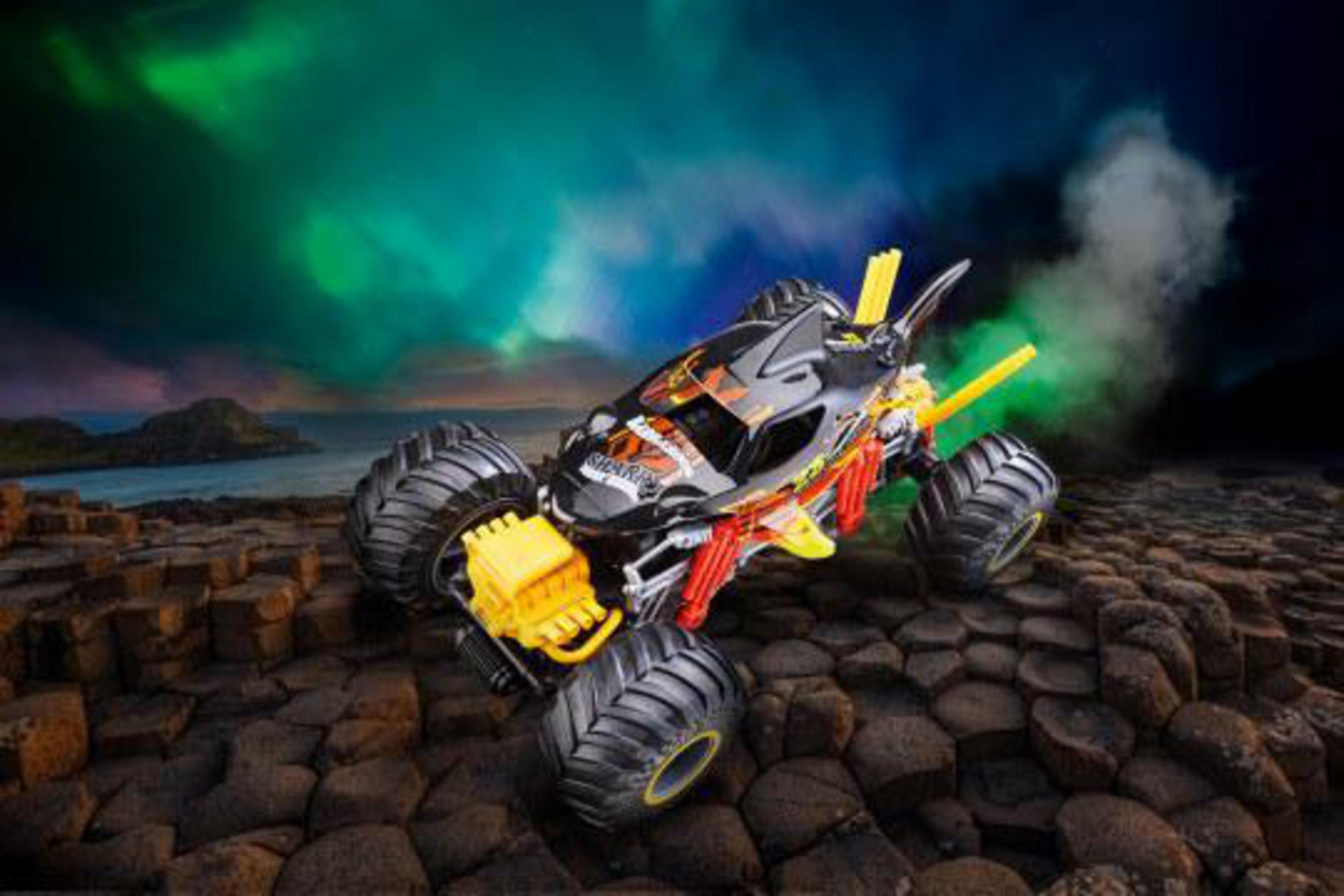 Spielzeug-Monstertruck auf felsigem Gelände mit grün-lila Himmels Hintergrund.