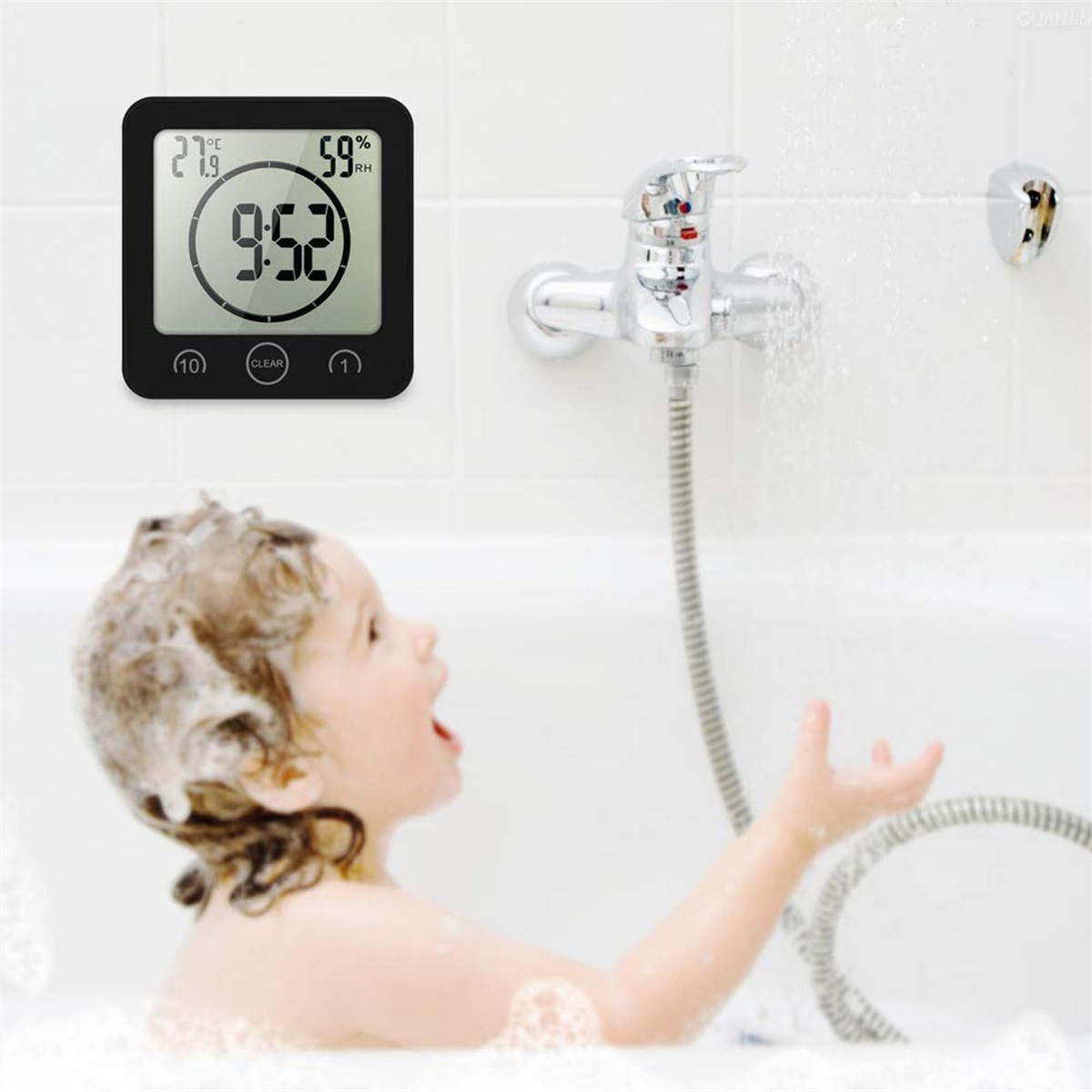 Ein Kind in einer Badewanne, mit fließendem Wasser und einem digitalen Thermometer, das Zeit und Temperatur anzeigt.
