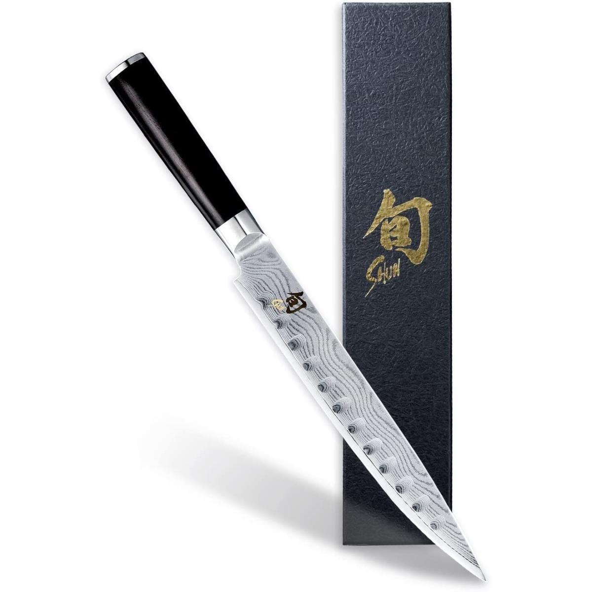 Ein japanisches Kochmesser mit schwarzem Griff in einer schwarzen Box mit Goldtext.