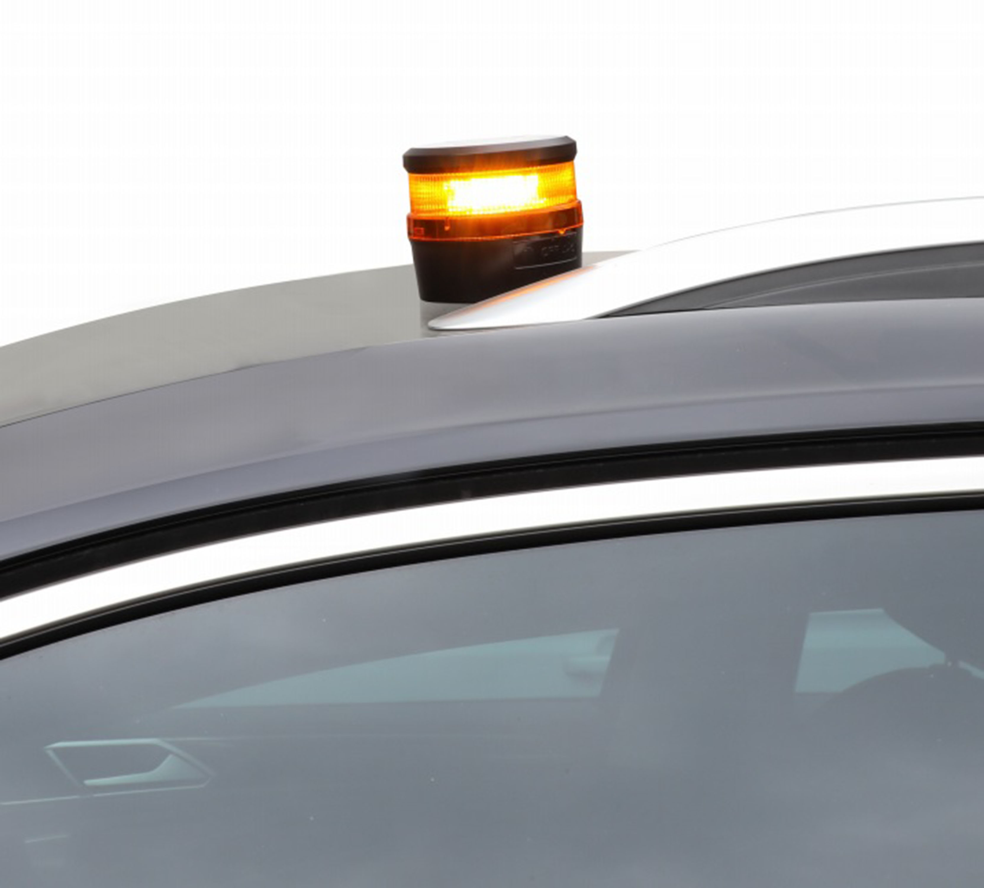 Un techo de coche con una luz intermitente naranja encima, sobre un fondo blanco.