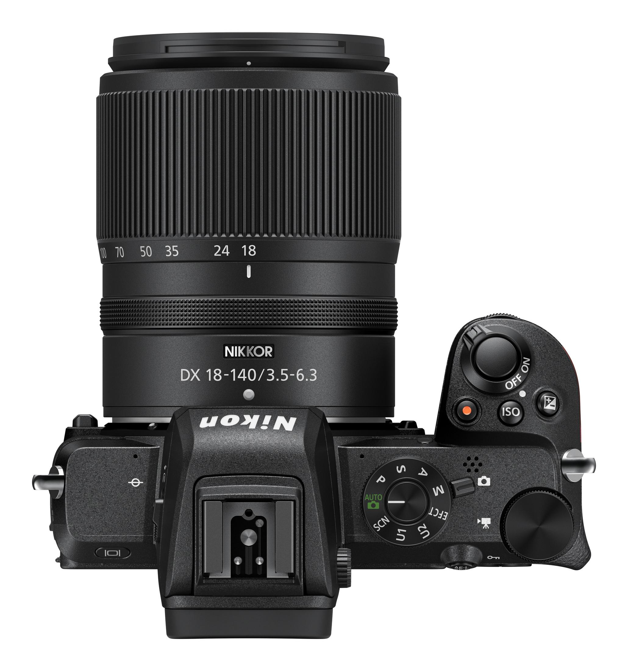 Eine schwarze Nikon-Kamera mit Objektiv, Draufsicht auf weißem Hintergrund.