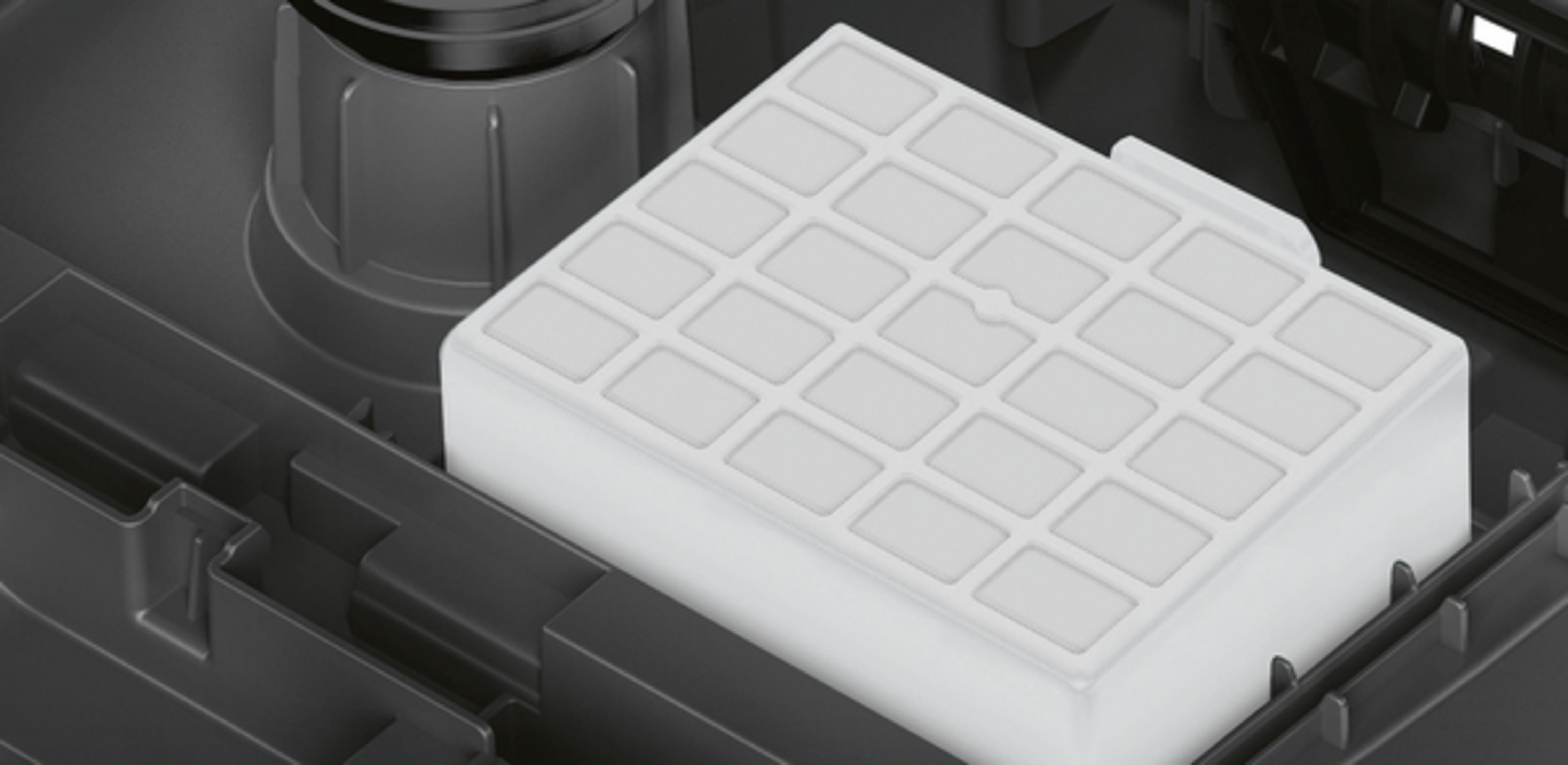Un filtro bianco per elettrodomestici, con un design a griglia, in un vano scuro.