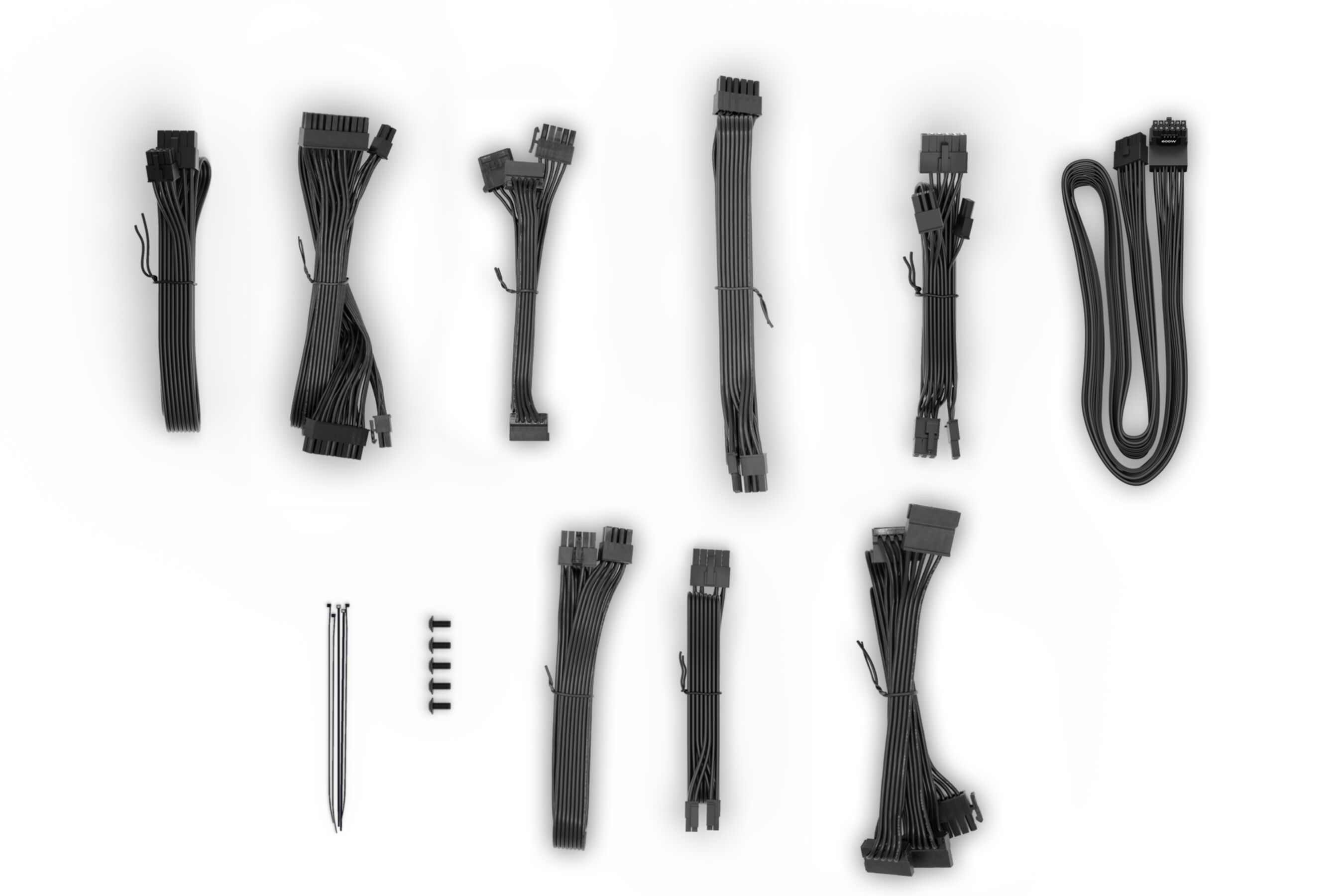 Zbiór czarnych kabli i złączy zasilacza komputerowego na białej powierzchni.