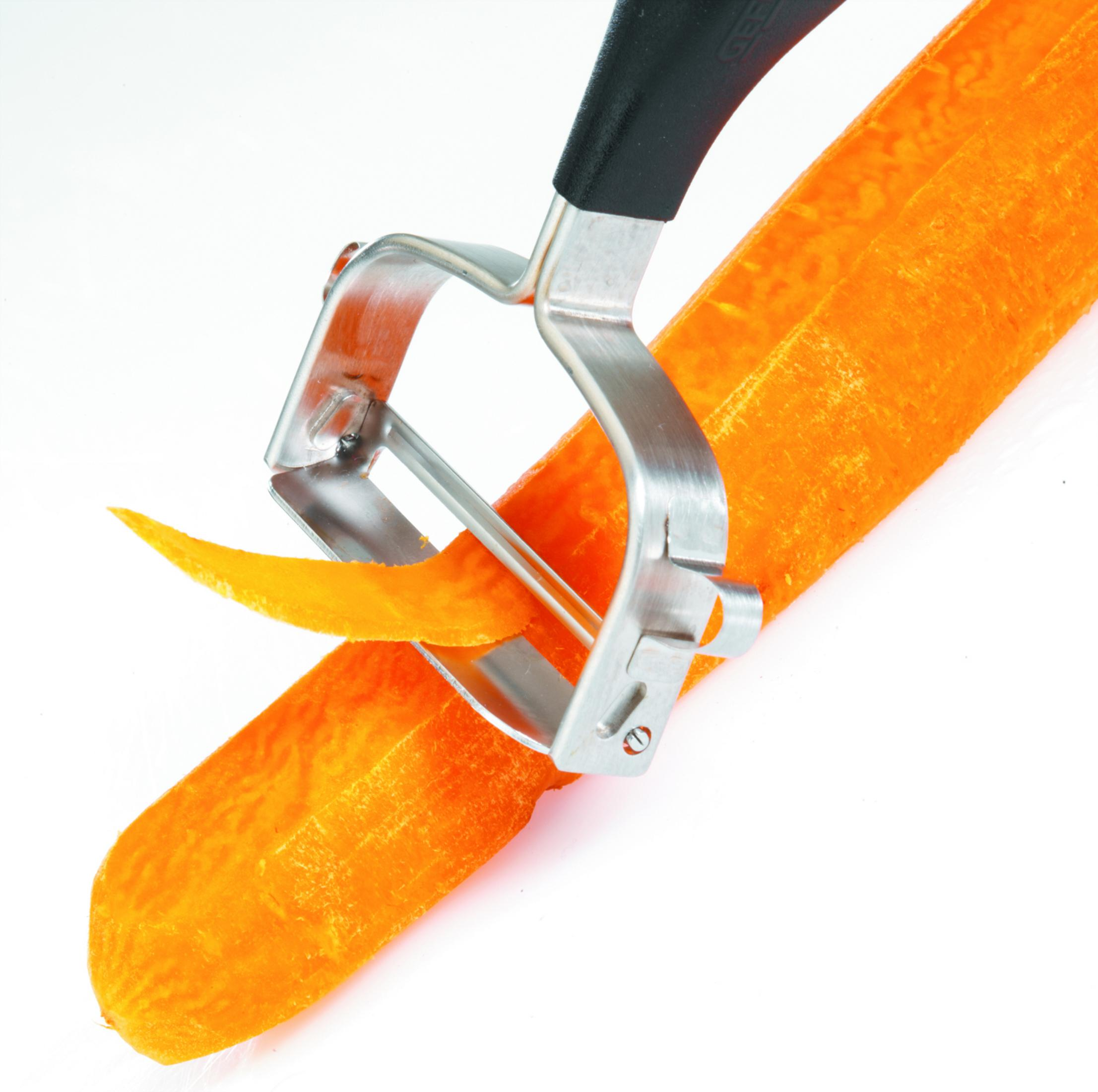 Marchew obierana srebrną obieraczką, pomarańczowa skórka się zwija.