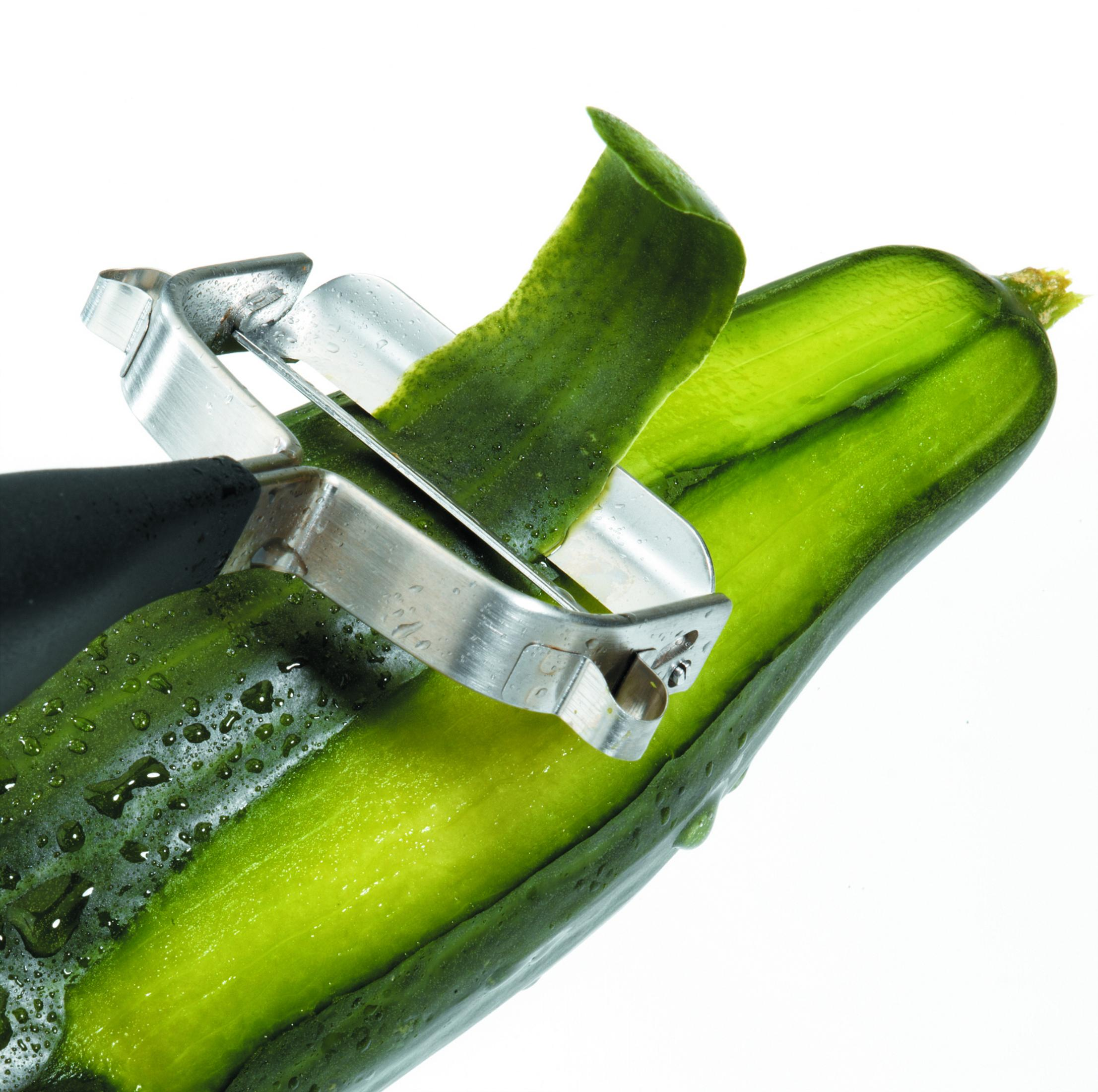 Ogórek obrany srebrną obieraczką. Zielona skórka się odkleja.