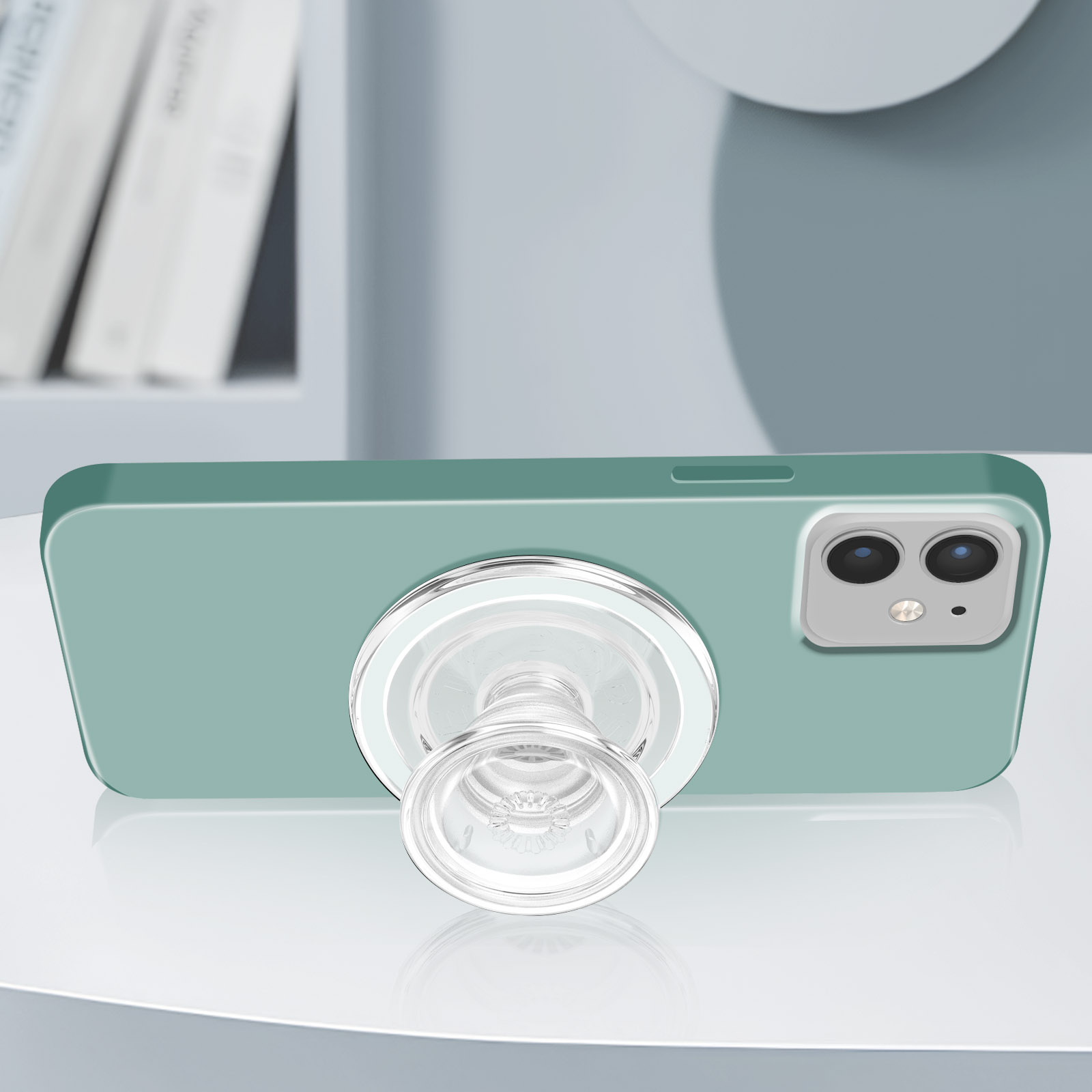 Grünes Telefon mit Pop-Socket. Das Telefon liegt auf einer reflektierenden Oberfläche.