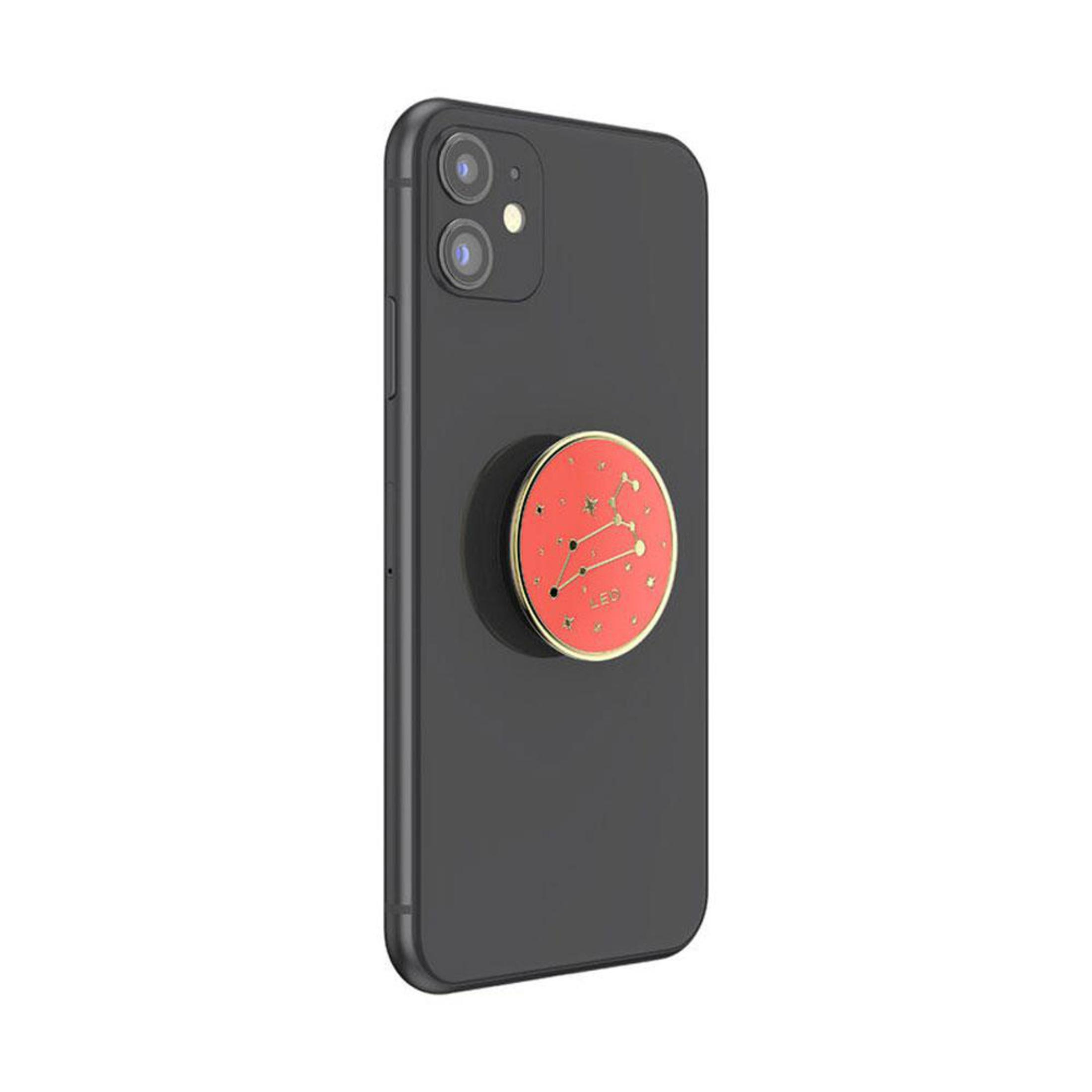 Schwarzes Telefon mit rotem Leo-Pop-Socket. Der Pop-Socket hat goldfarbene Verzierungen und Sternbilder.