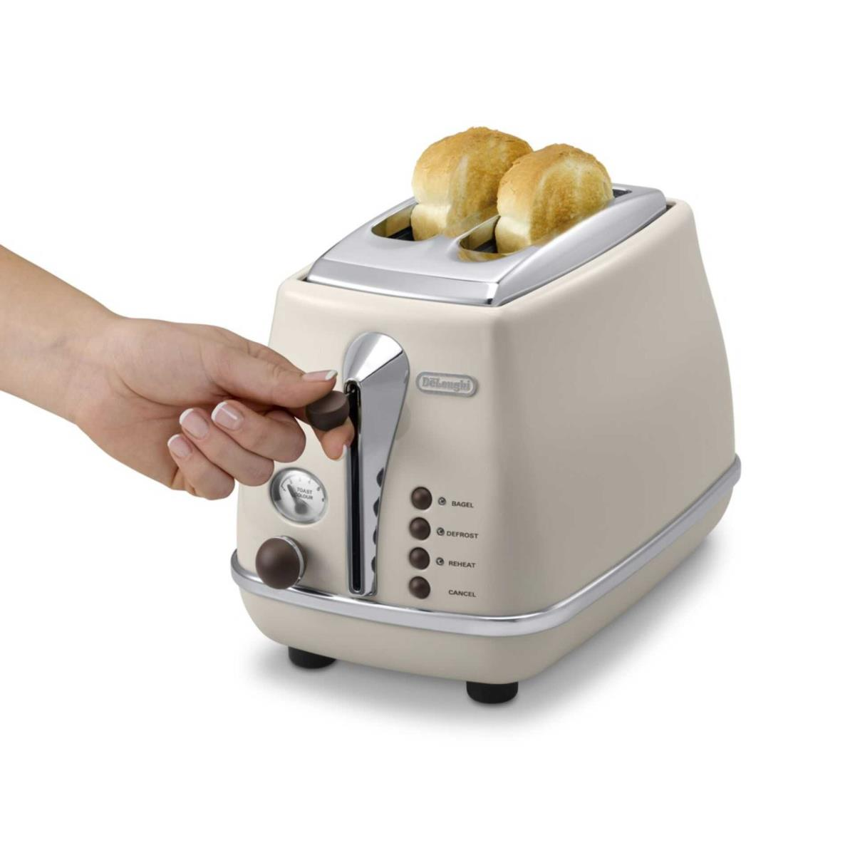 İki dilim tost ve kolu çeken bir el ile krem rengi bir tost makinesi.