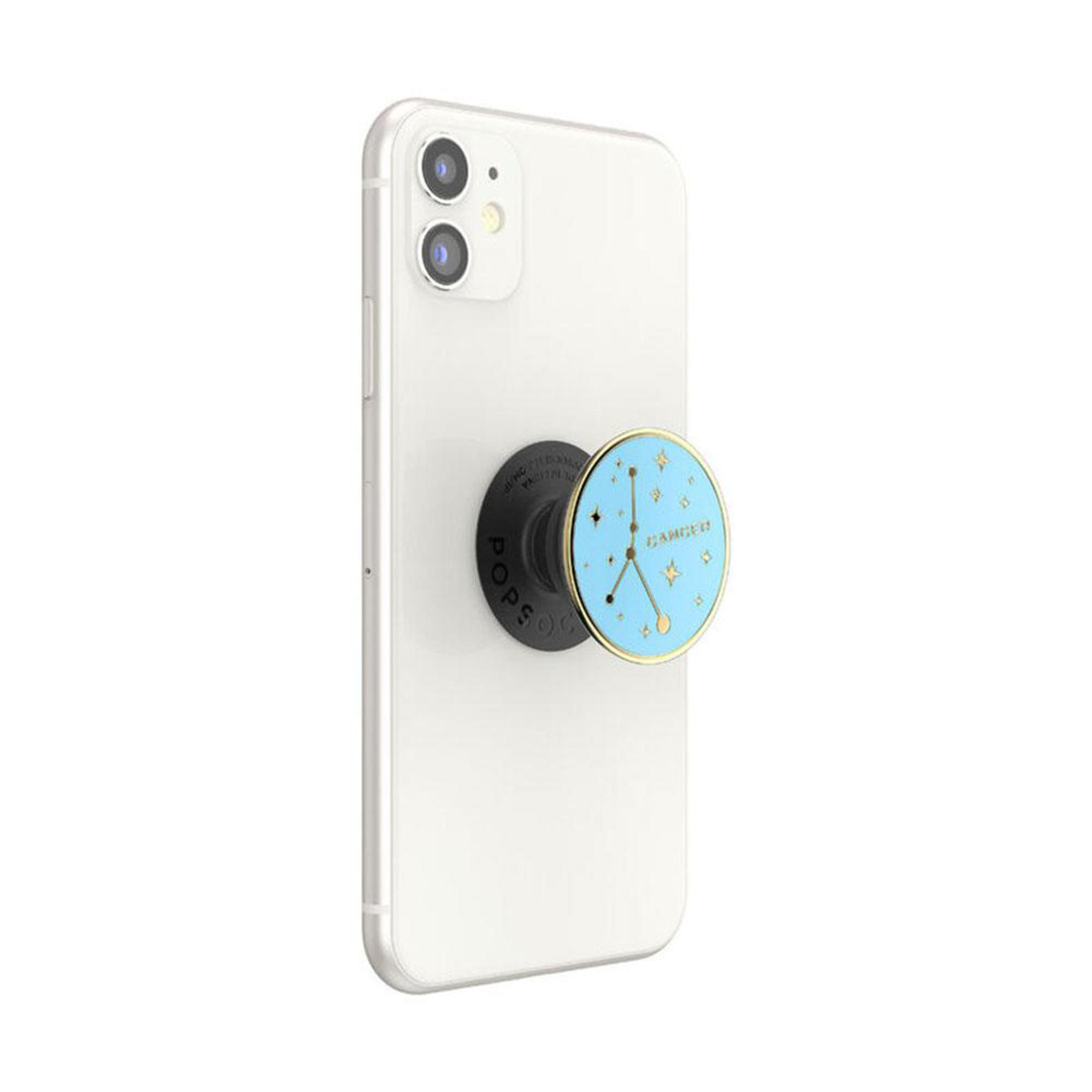 Weißes Telefon mit Pop-Socket, das ein Krebs-Zeichen auf der Rückseite zeigt.