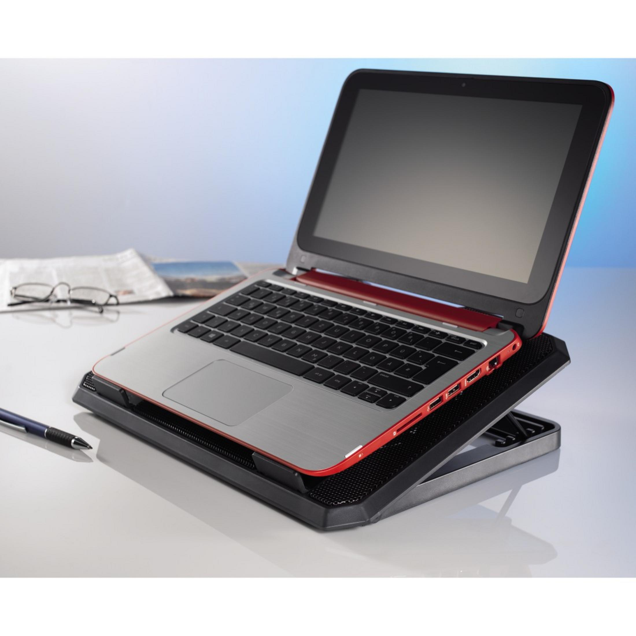 Ein Laptop auf einem Kühlpad mit Stift und Brille auf weißer Oberfläche mit blauem Hintergrund.