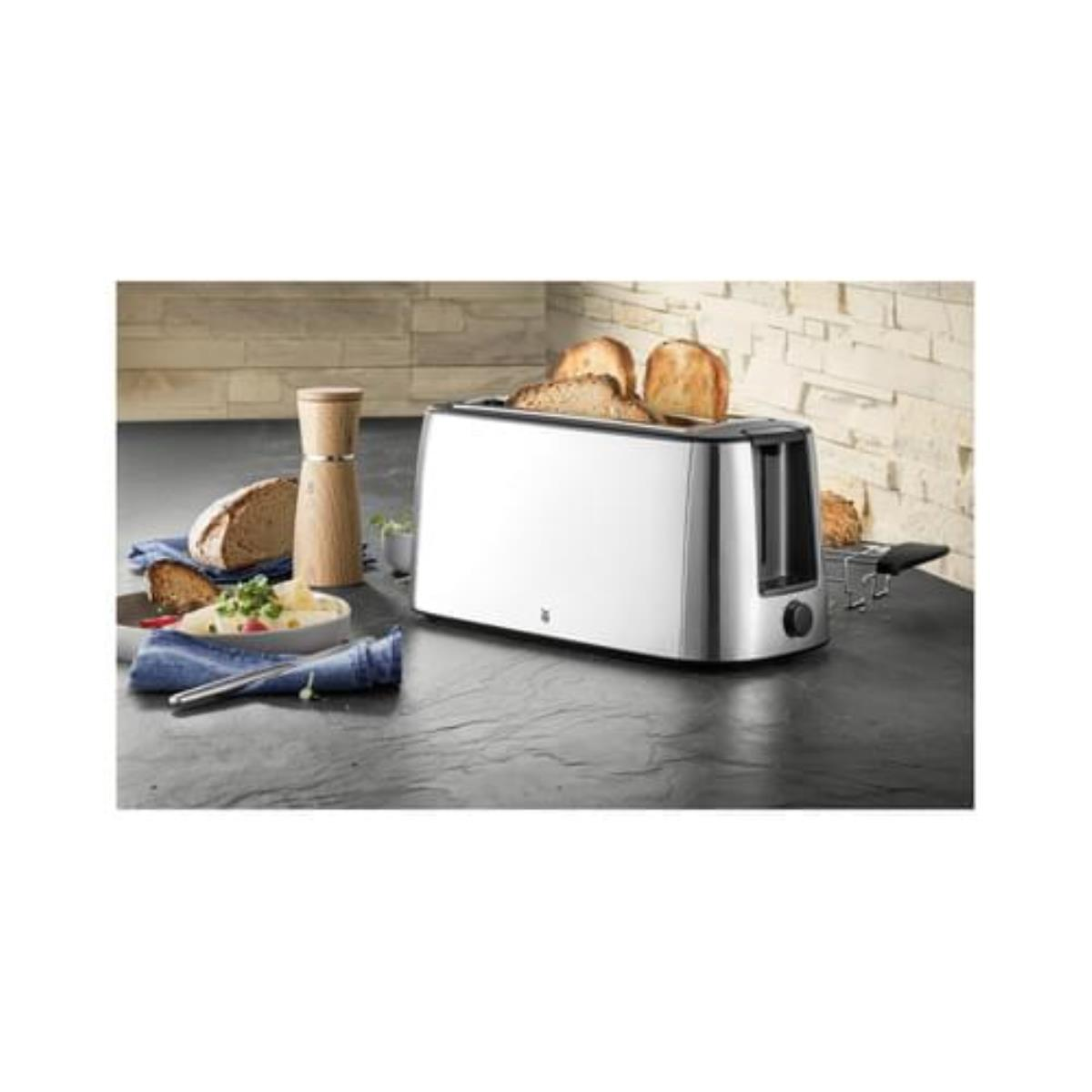 Edelstahl-Toaster mit Brot darin, plus Brot, Butter und einem Holzschleifer.