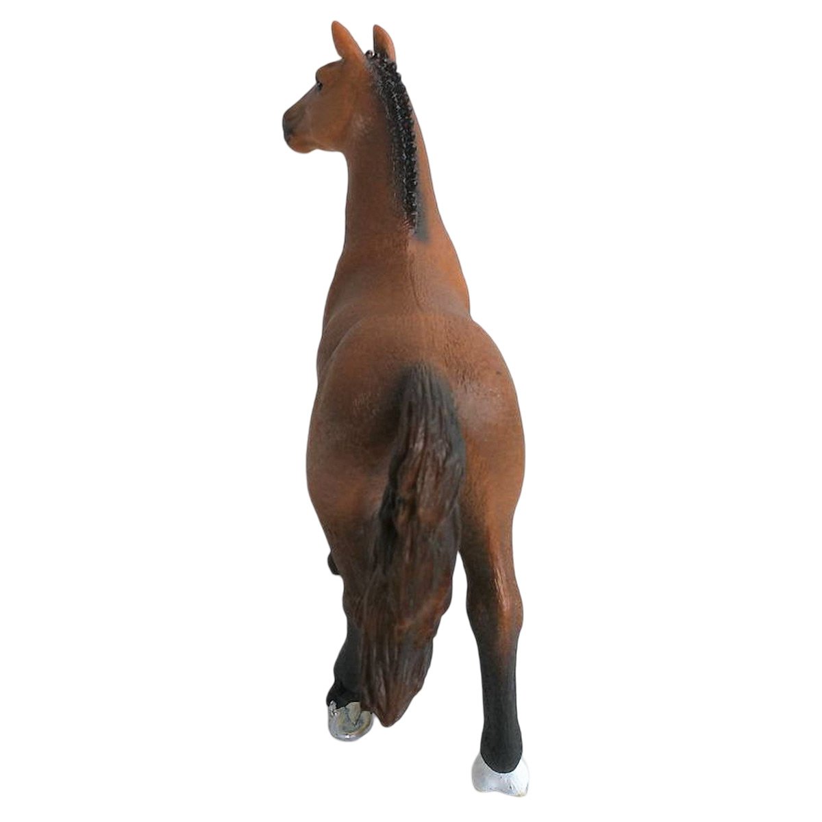 Una statuina di cavallo marrone in piedi e di spalle. La coda del cavallo è visibile.