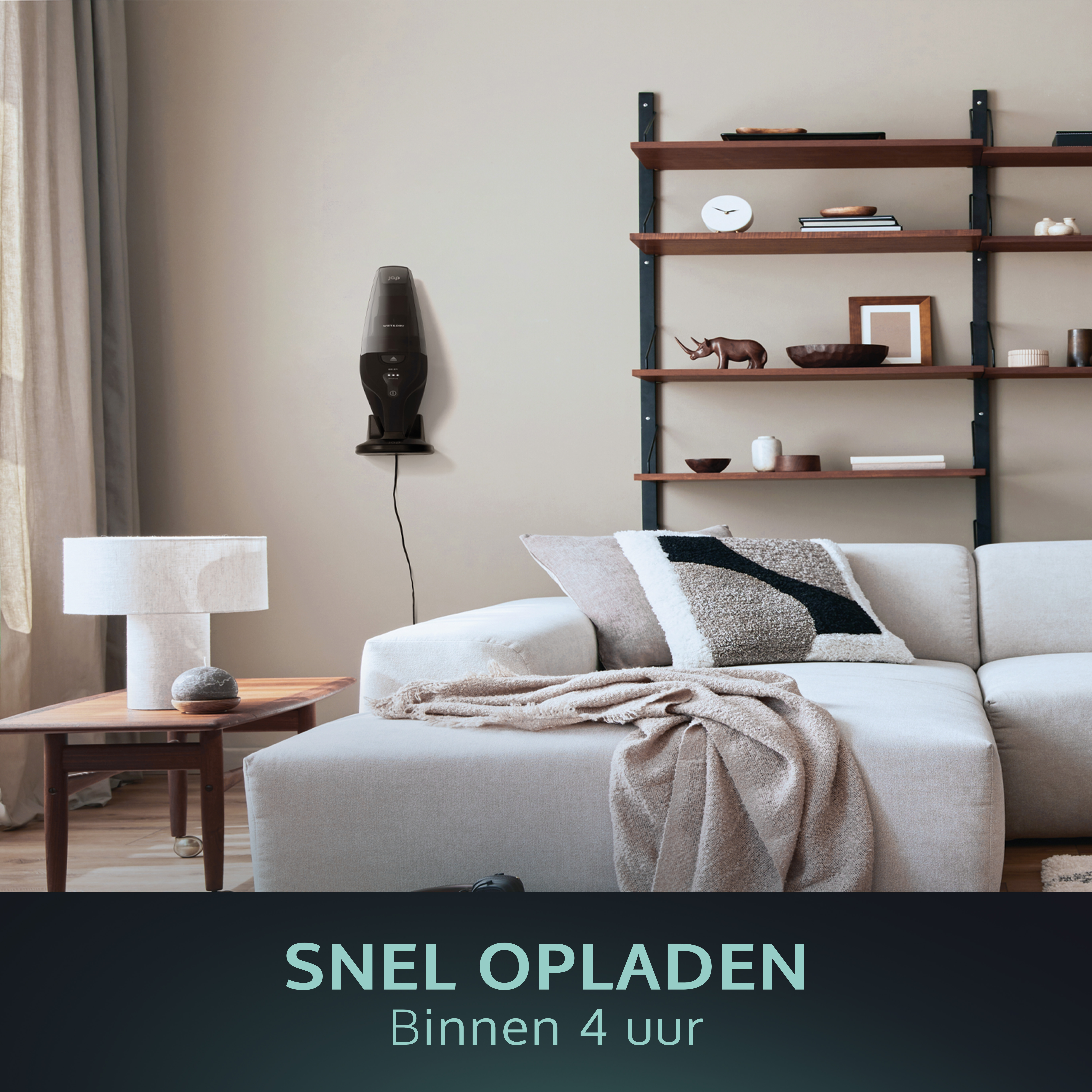 Ein schwarzer Staubsauger hängt an einer Wand, eine Couch und ein Tisch. Text am unteren Bildrand.