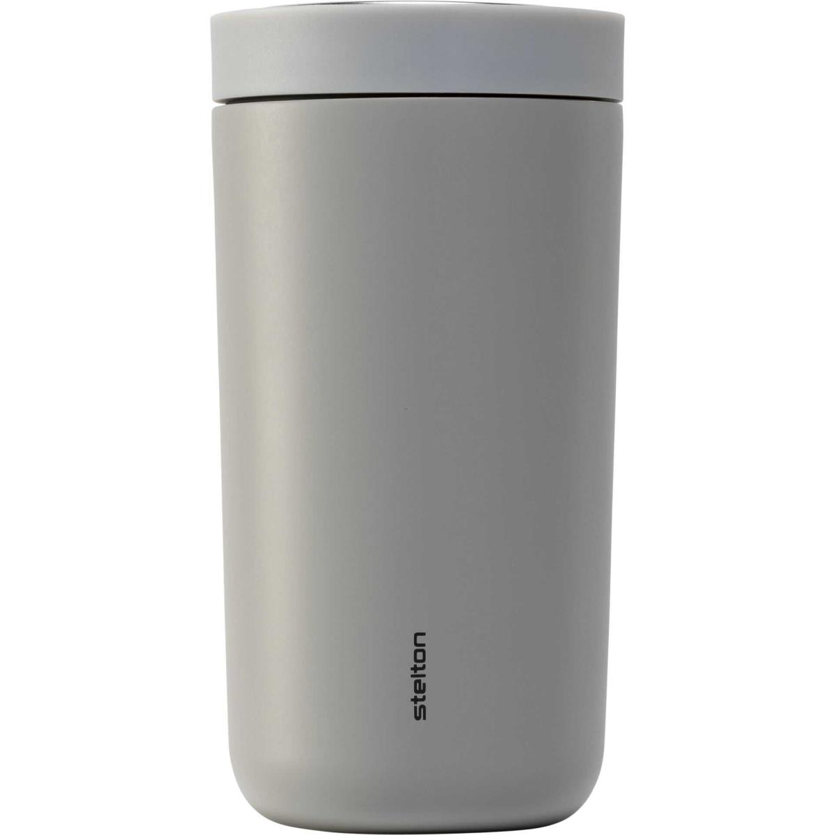 Ein grauer, zylindrischer Reisebecher mit weißem Deckel und dem Wort „Stelton“ an der Seite.