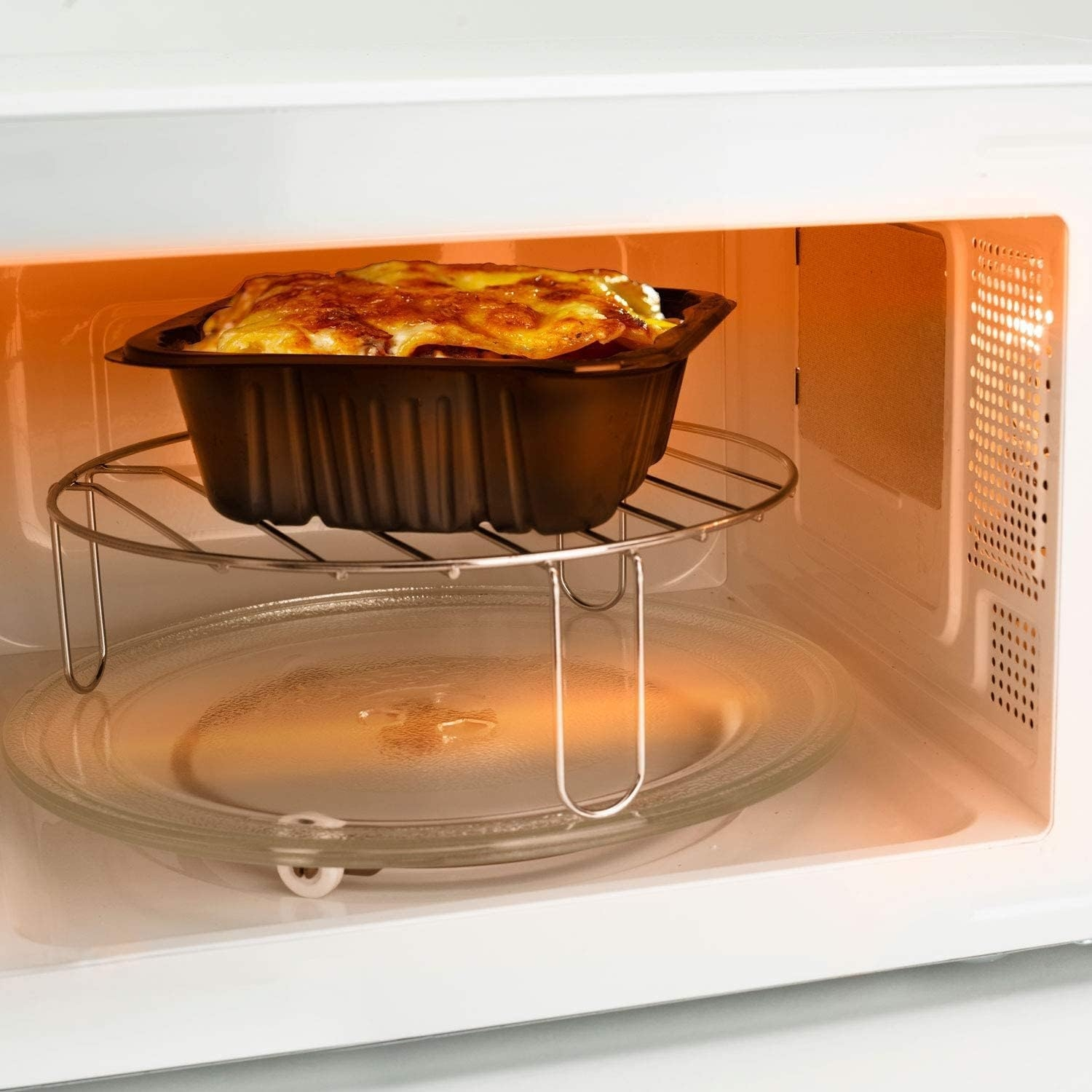 Binnenin een magnetron wordt een bakje met eten verwarmd. De binnenkant is helder, met een glazen plaat.