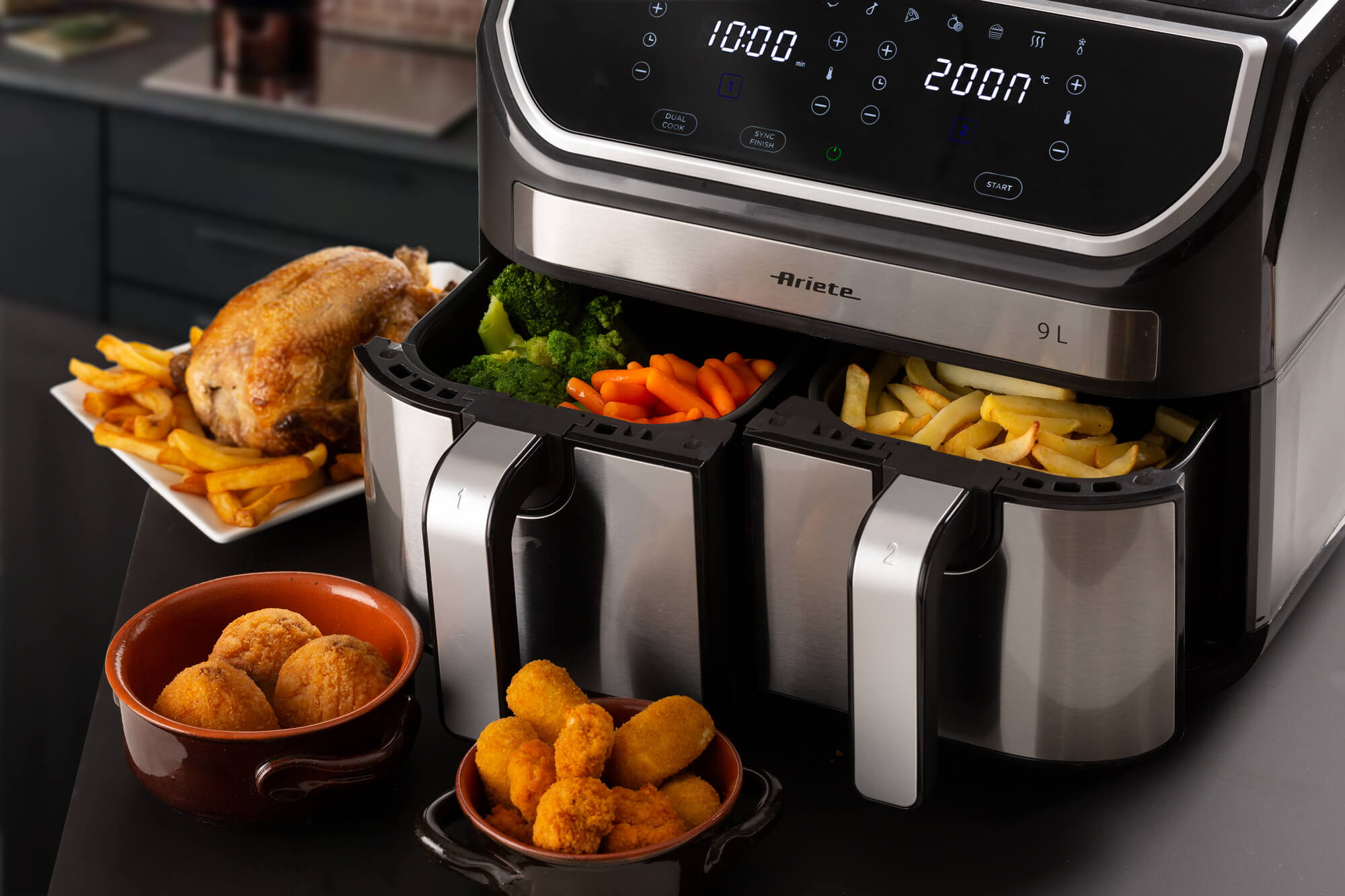 Airfryer met eten: kip, friet, broccoli, wortelen en kroketten.