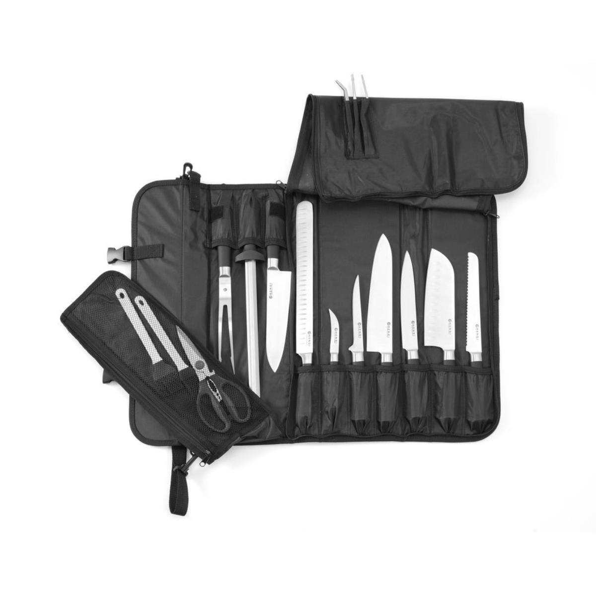 Eine schwarze Messertasche mit verschiedenen Messern und Utensilien. Die Tasche liegt auf weißem Grund.