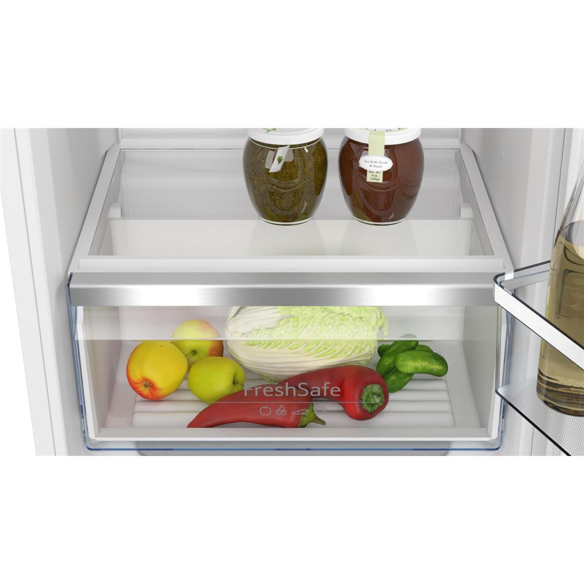 Nahaufnahme der Gemüseschublade eines Kühlschranks mit Äpfeln, Paprika und Kohl.