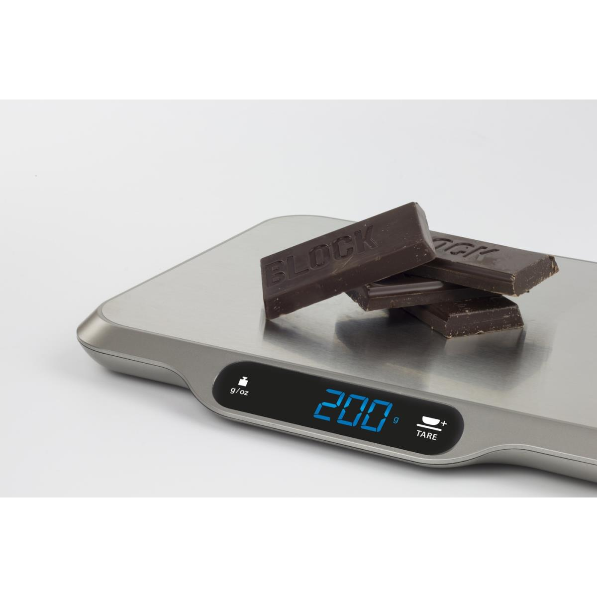 Eine Digitalwaage mit Schokoriegeln, die 200g anzeigt. Die Waage ist silberfarben mit schwarzem Display.