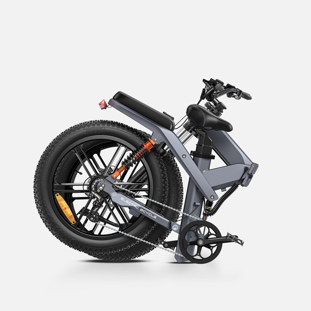 Bicicleta eléctrica gris plegada. Características incluyen neumáticos grandes, suspensión trasera y asiento negro.