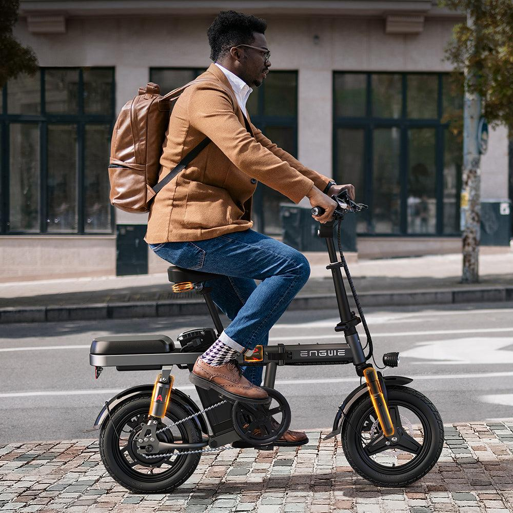 Un uomo che guida uno scooter elettrico nero e giallo in una strada cittadina.