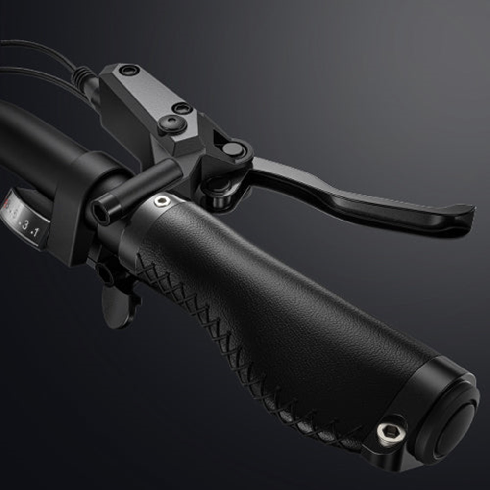 Manillar de bicicleta negro, primer plano. Detalle agarre, freno y indicador.