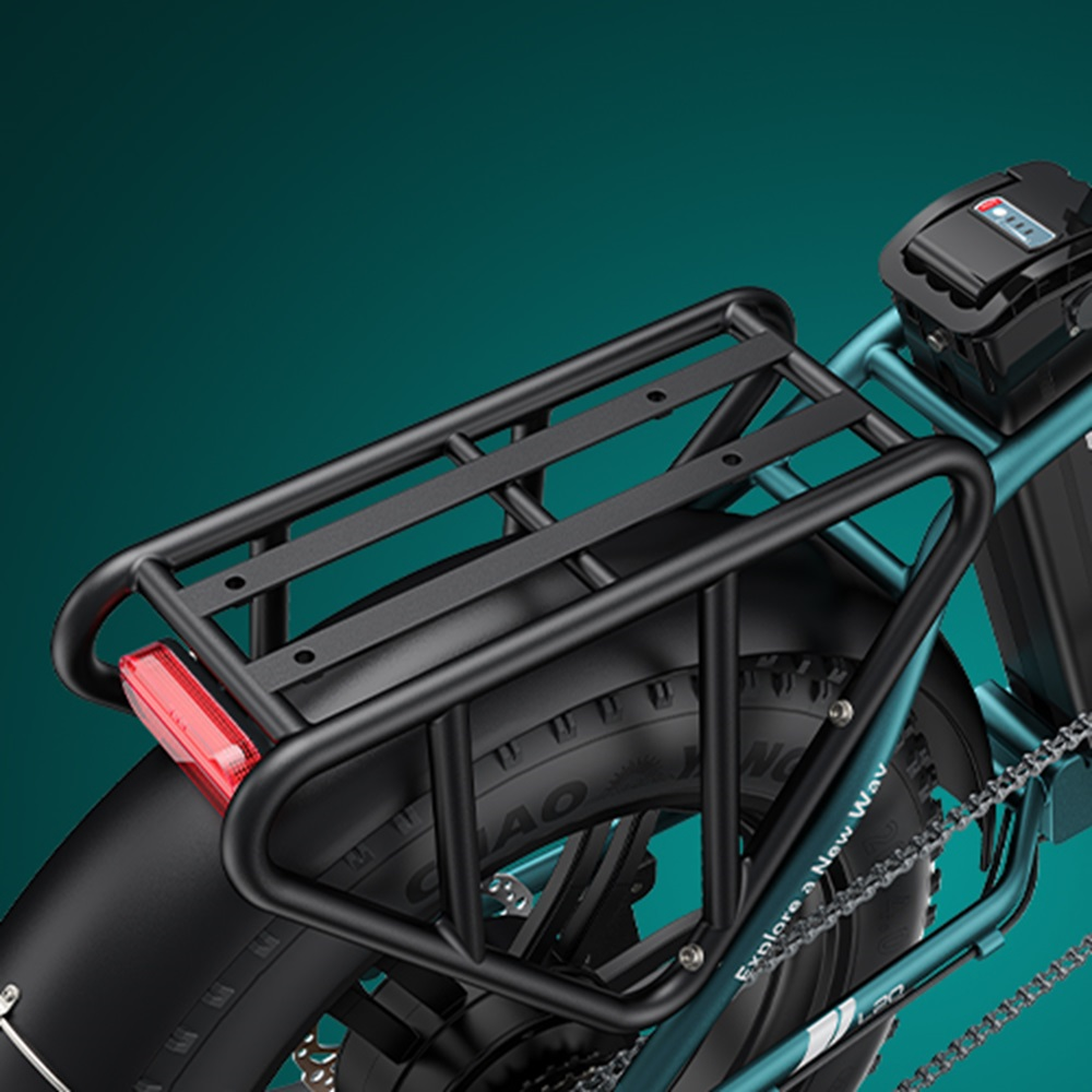Nahaufnahme des Gepäckträgers eines teal-farbenen Elektrofahrrads mit schwarzem Träger und rotem Reflektor.