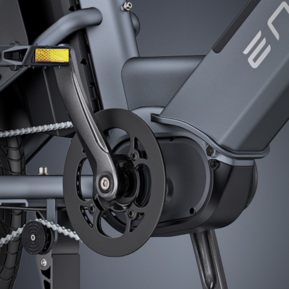 Nahaufnahme von Elektrofahrradpedal und Getriebesystem, Kette und Motor sichtbar.
