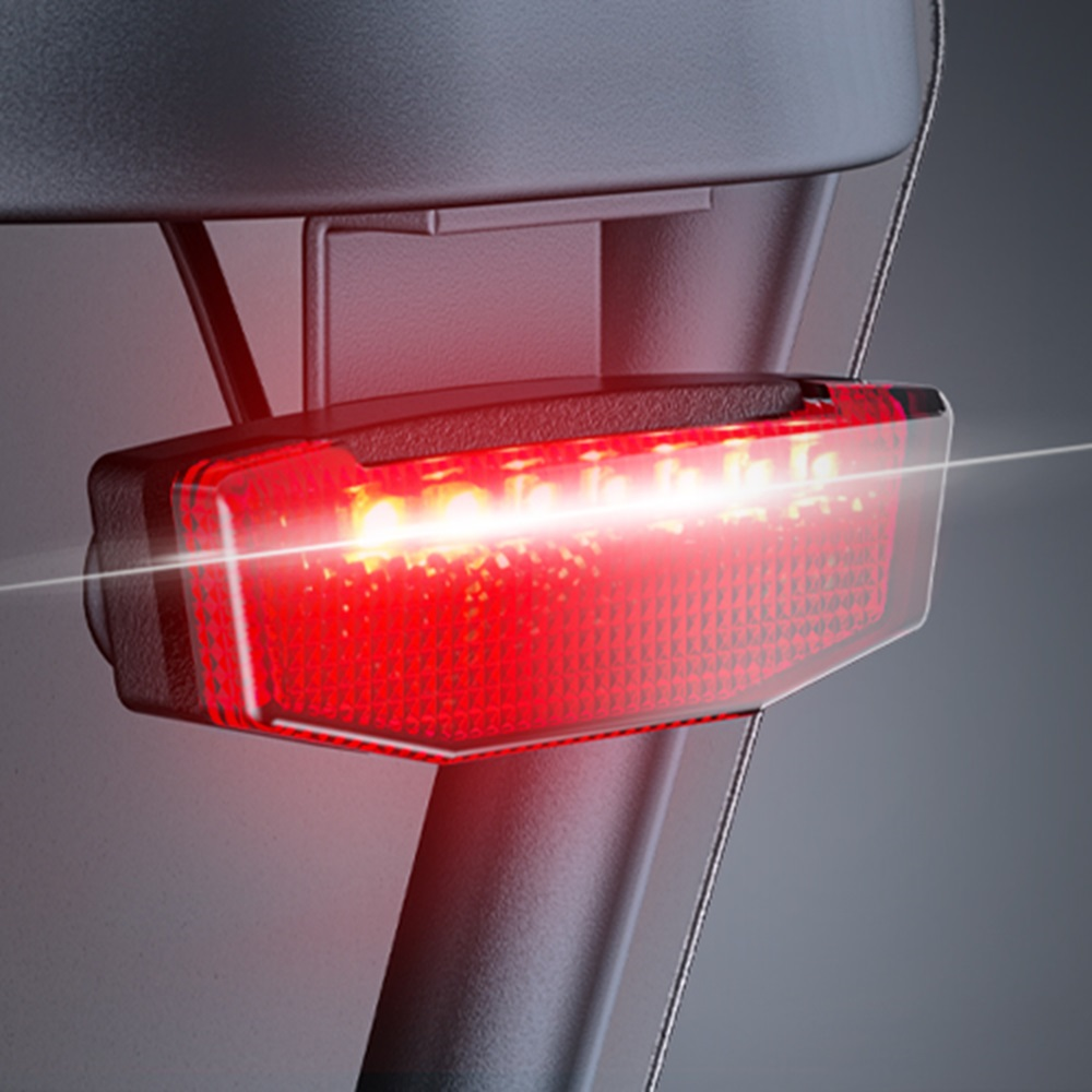 Rotes Fahrradlicht mit schwarzem Rahmen, beleuchtet.