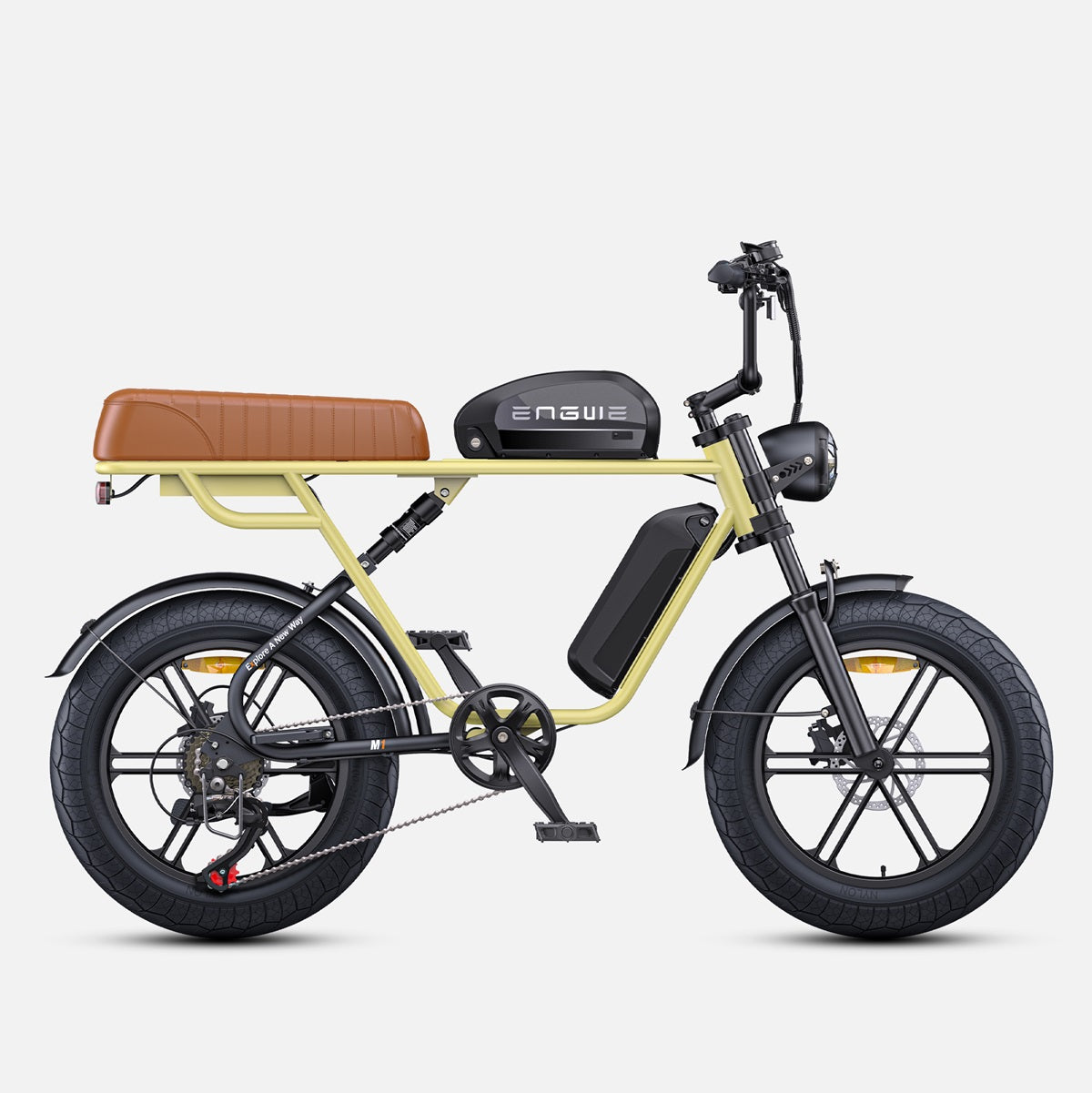 Motocicleta amarilla con asiento marrón, neumáticos negros y motor negro sobre superficie blanca.