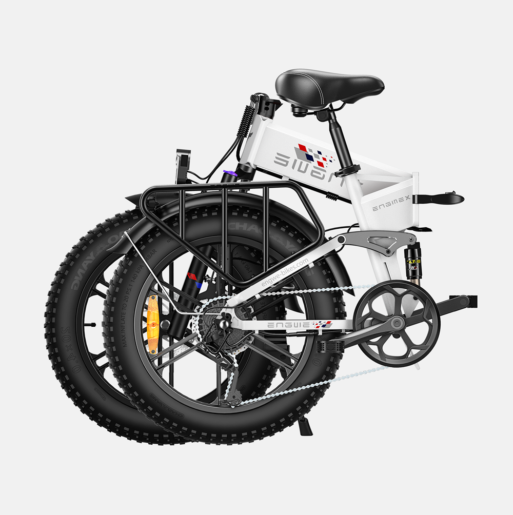 Bicicleta plegable blanca, plegada, con neumáticos negros y portaequipajes negro.