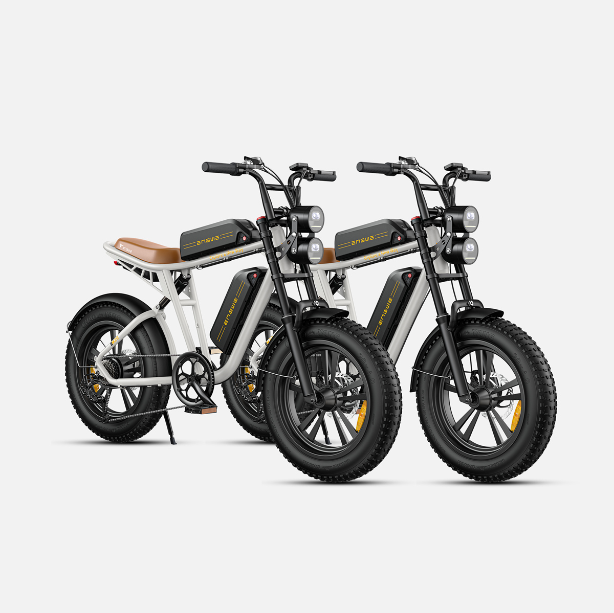 Dos bicicletas eléctricas blancas y negras una al lado de la otra, fondo blanco.