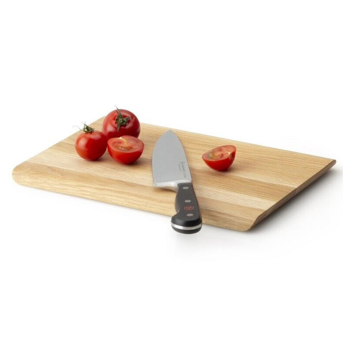 Holzschneidebrett mit Messer und halbierten Tomaten neben ganzen. Weißer Hintergrund.