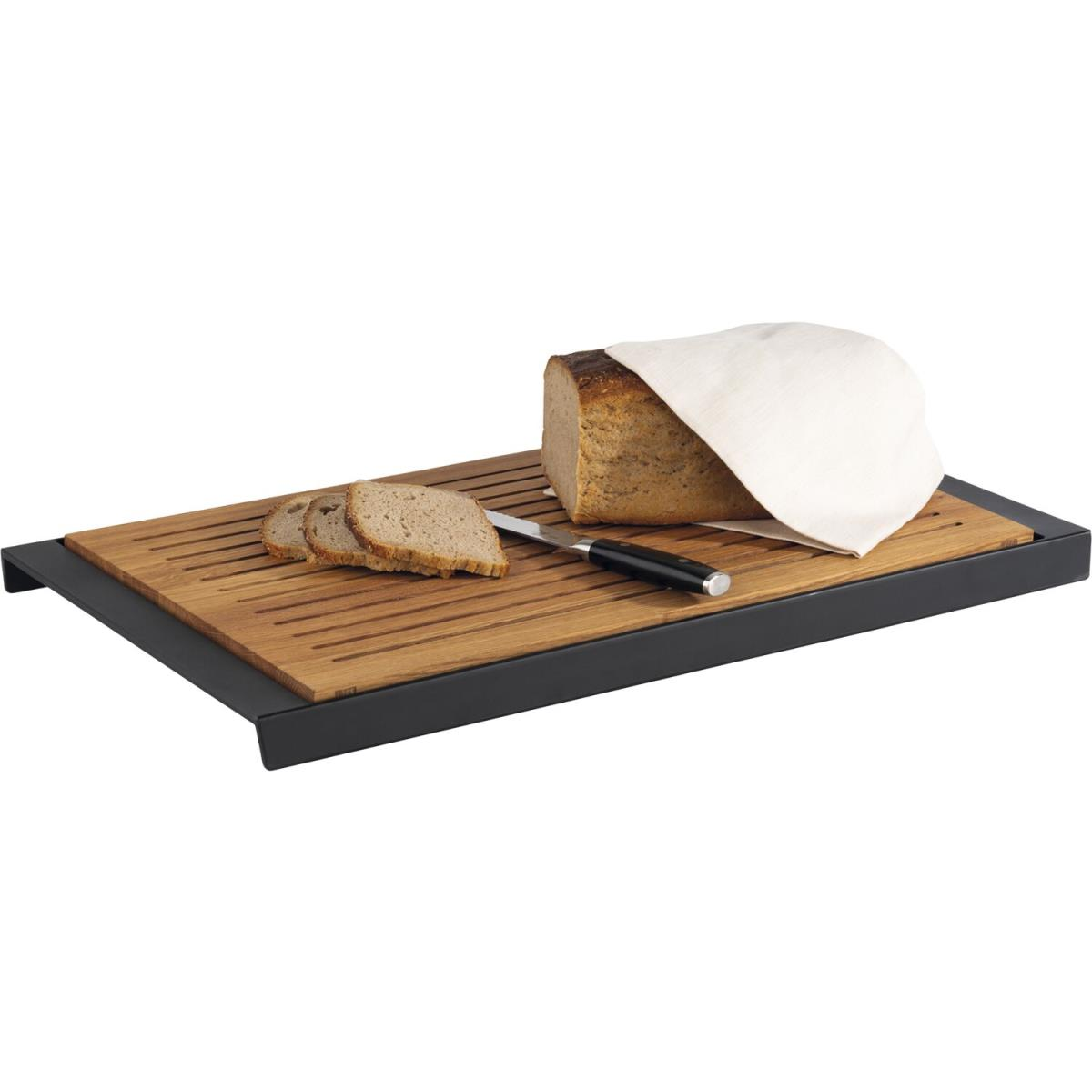 Ein hölzernes Schneidebrett mit schwarzem Rahmen, Brotscheiben, Messer und ein Brotlaib unter einem Tuch.