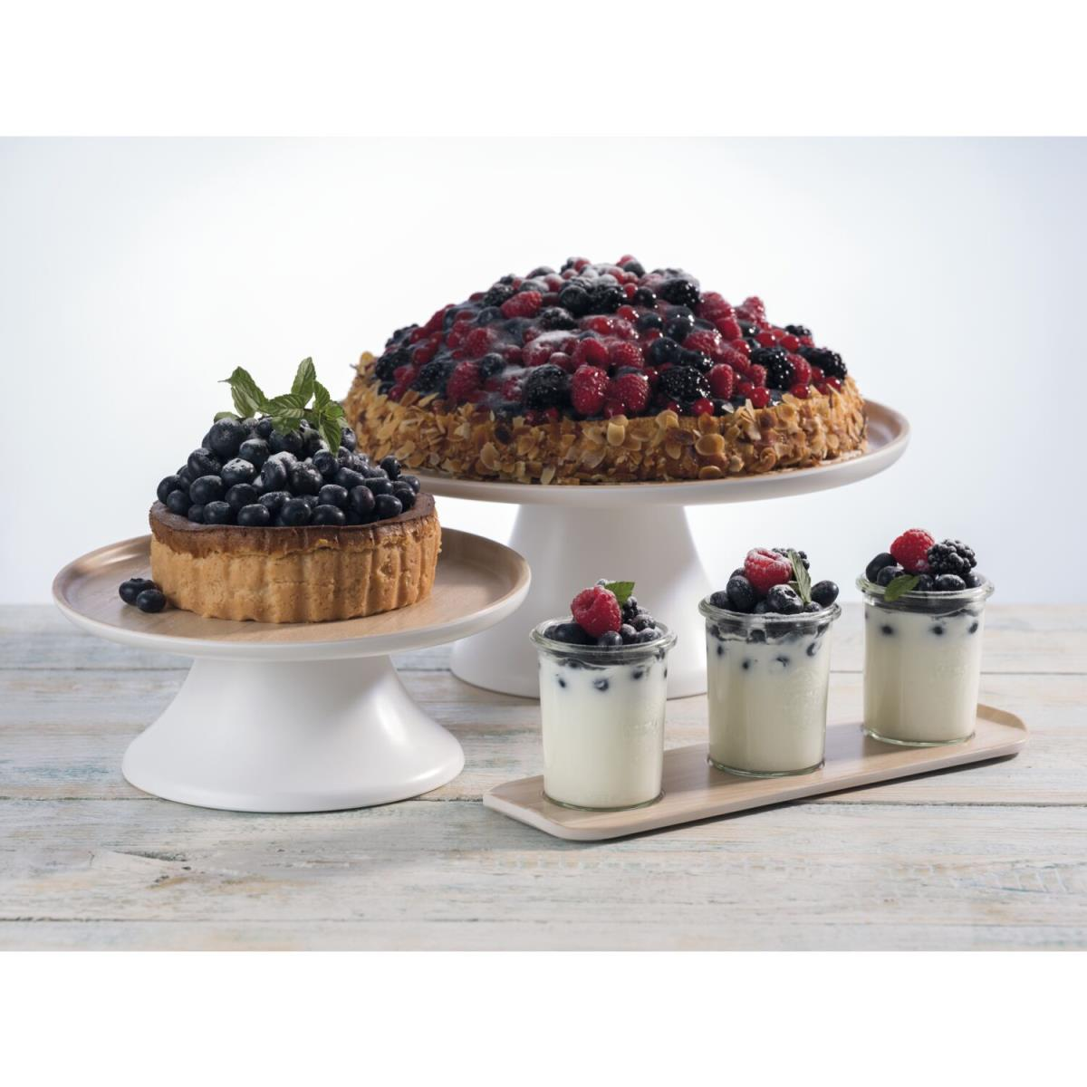 Verschiedene Desserts auf Servierständern. Kuchen, Torten und Parfaits auf einem Tisch.