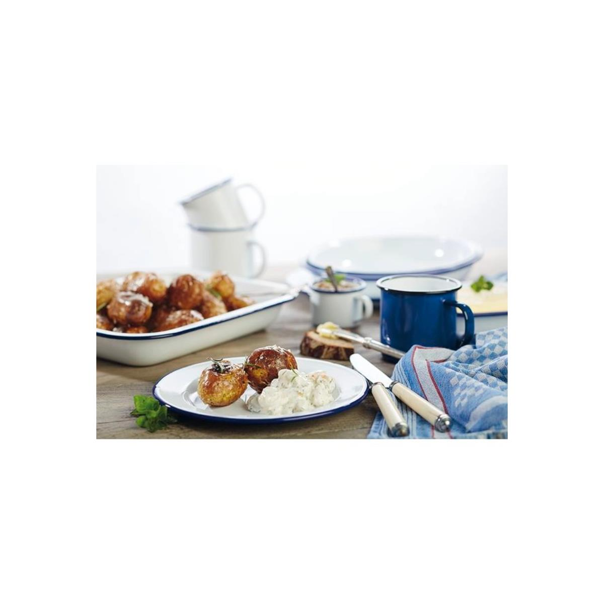 Ein Tischgedeck mit Essen, darunter Fleischbällchen, Kartoffeln und blau-weiße Keramiktassen und Teller.
